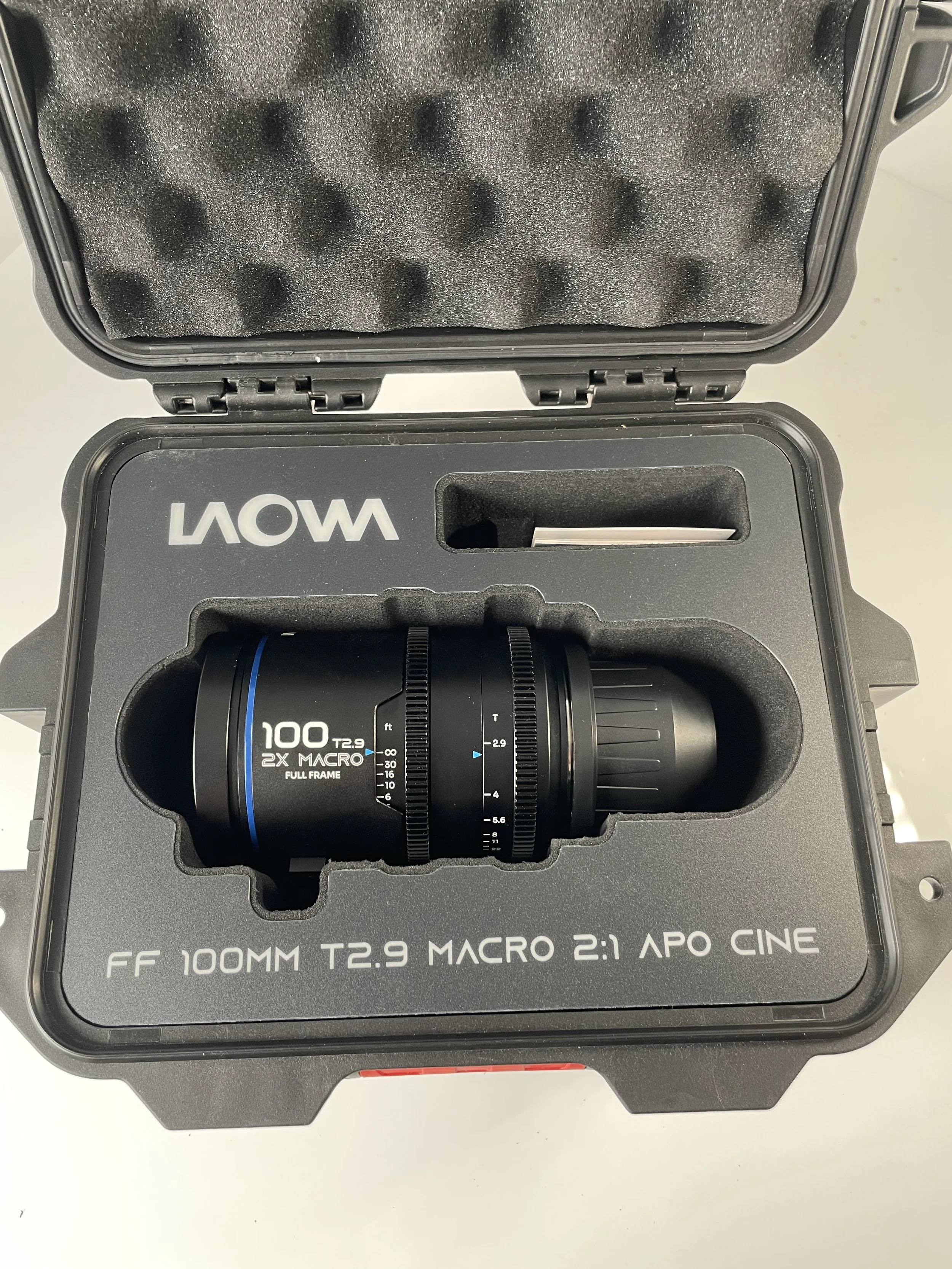 Laowa 100mm T2.9 Macro Cine shown in its case. Confirm included accessories.