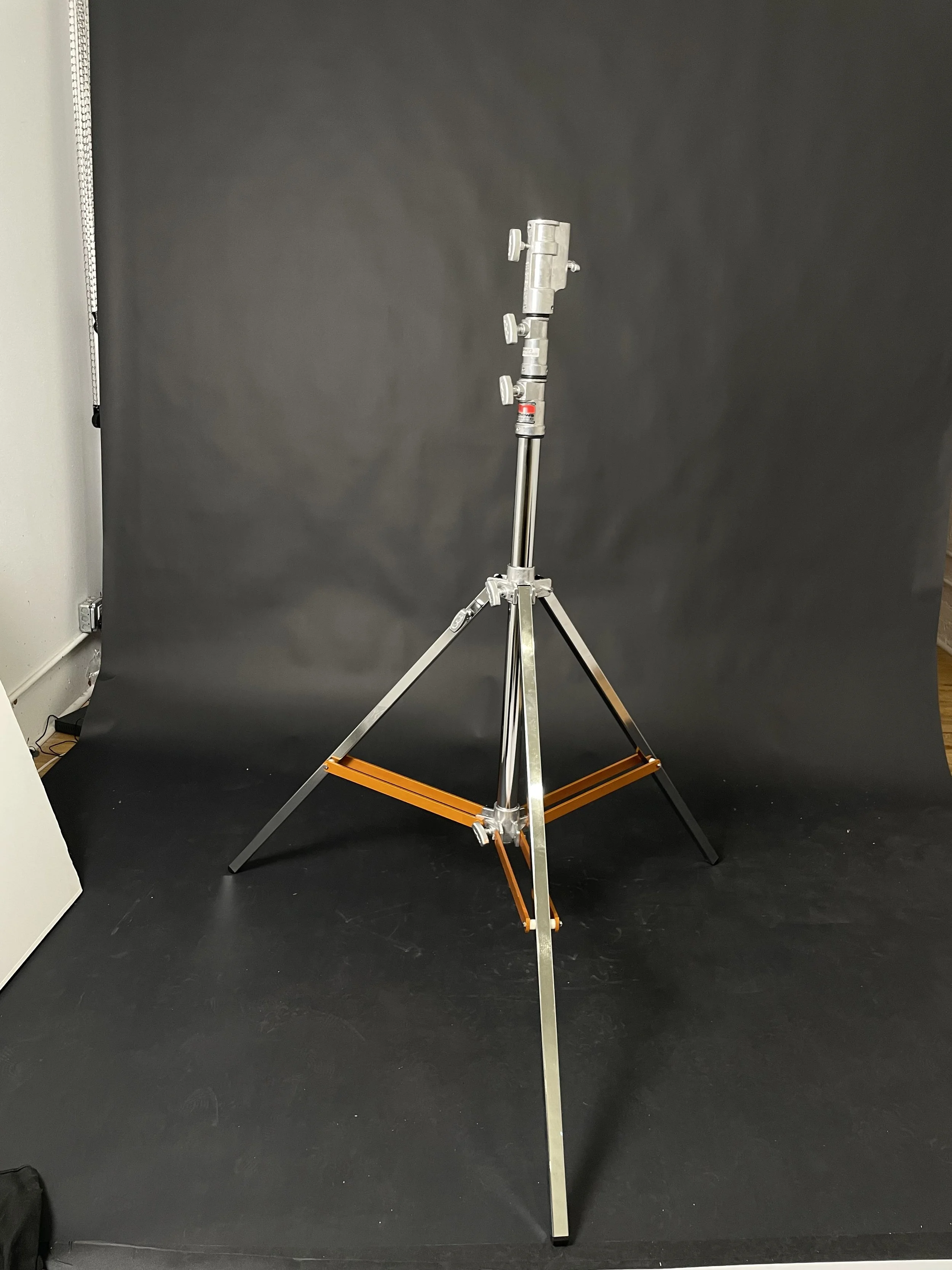 Silver light stand, open. Confirm model, height and load capacity.