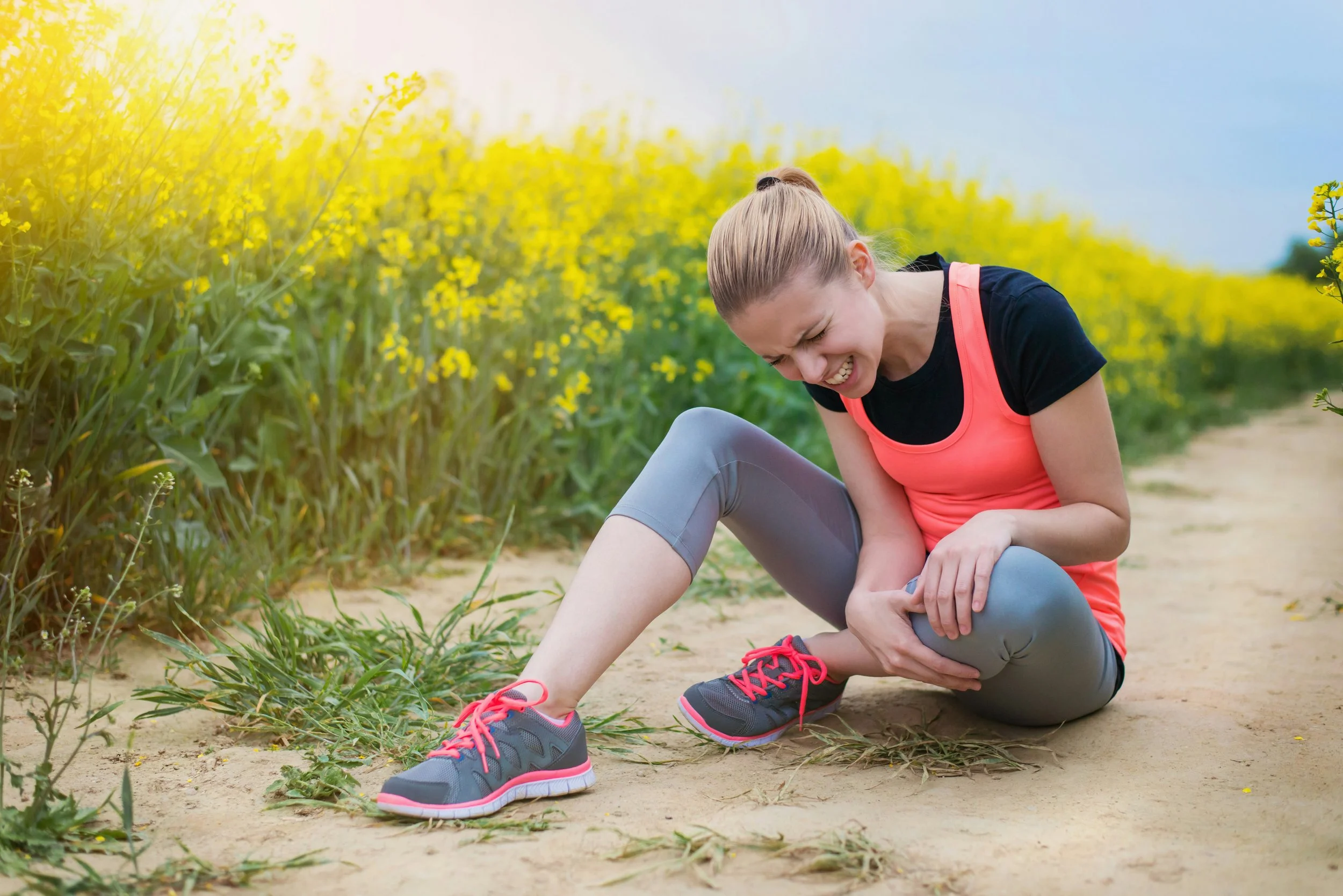 Runner pausing mid-run holding leg in discomfort