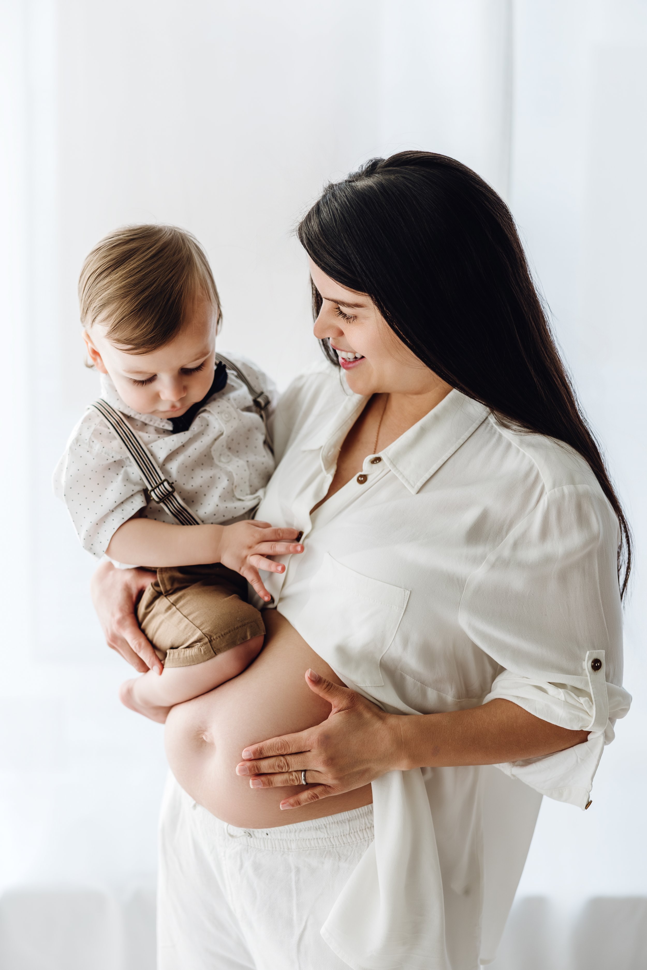 Babybauch Shooting Kassel – Geschwisterkind auf dem Arm der schwangeren Mutter – Fotografie Anne Günst