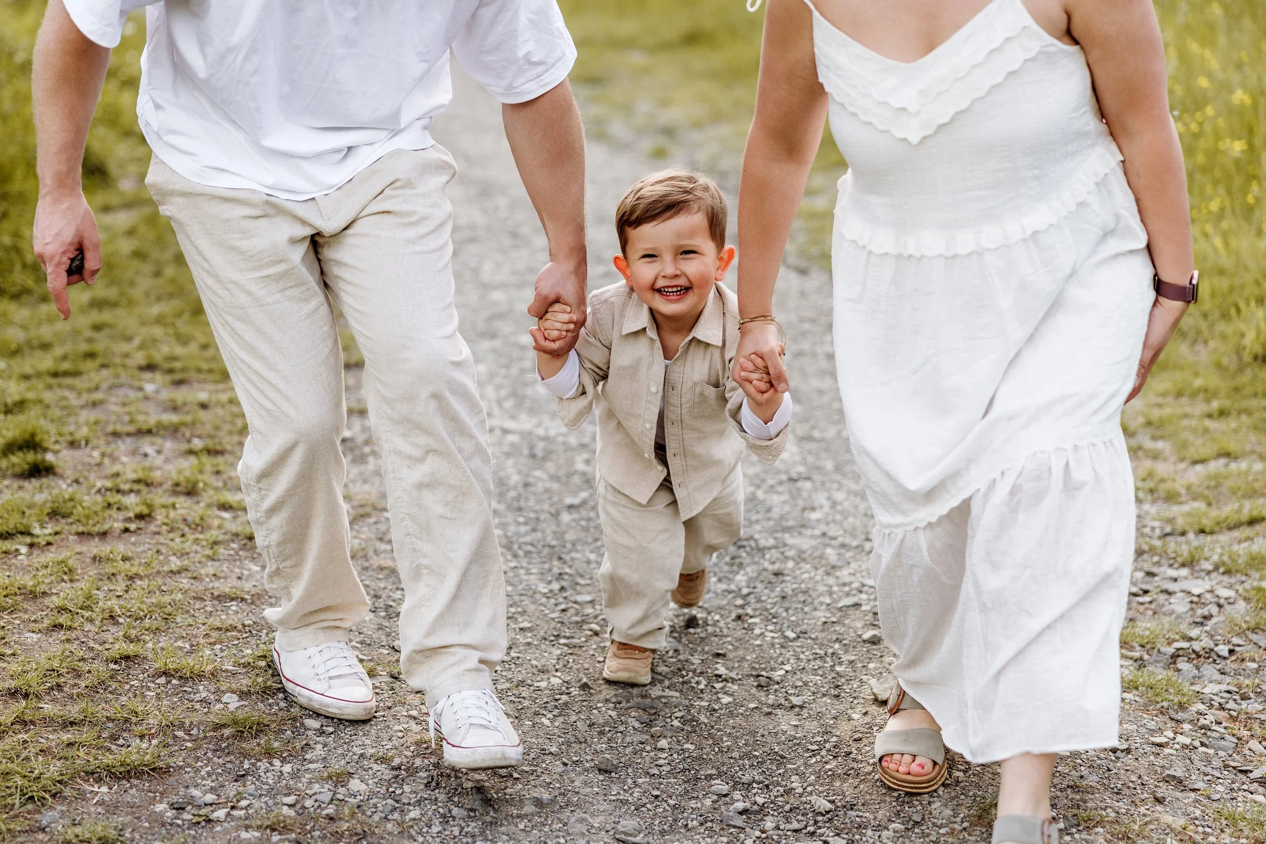Familienshooting Kassel – Kind lächelt an den Händen der Eltern – Fotografie Anne Günst