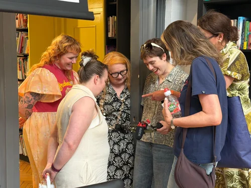 Educators laughing together around a camera