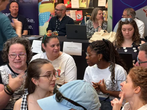 Educators in lively group discussion at a network event
