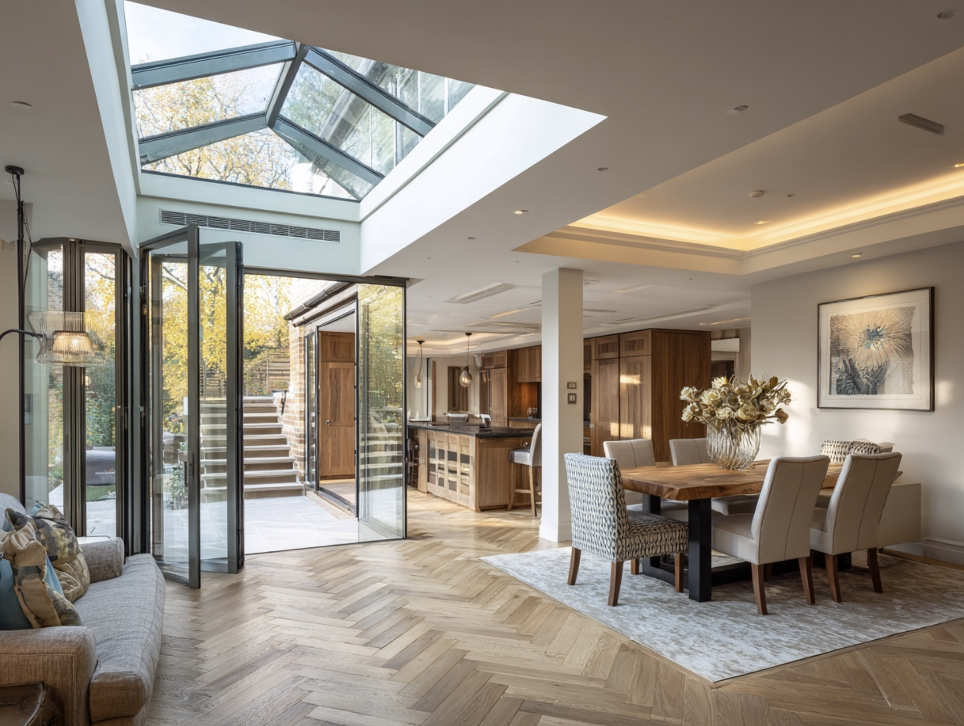 Contemporary UK kitchen extension with large roof lantern, bifold doors and herringbone flooring