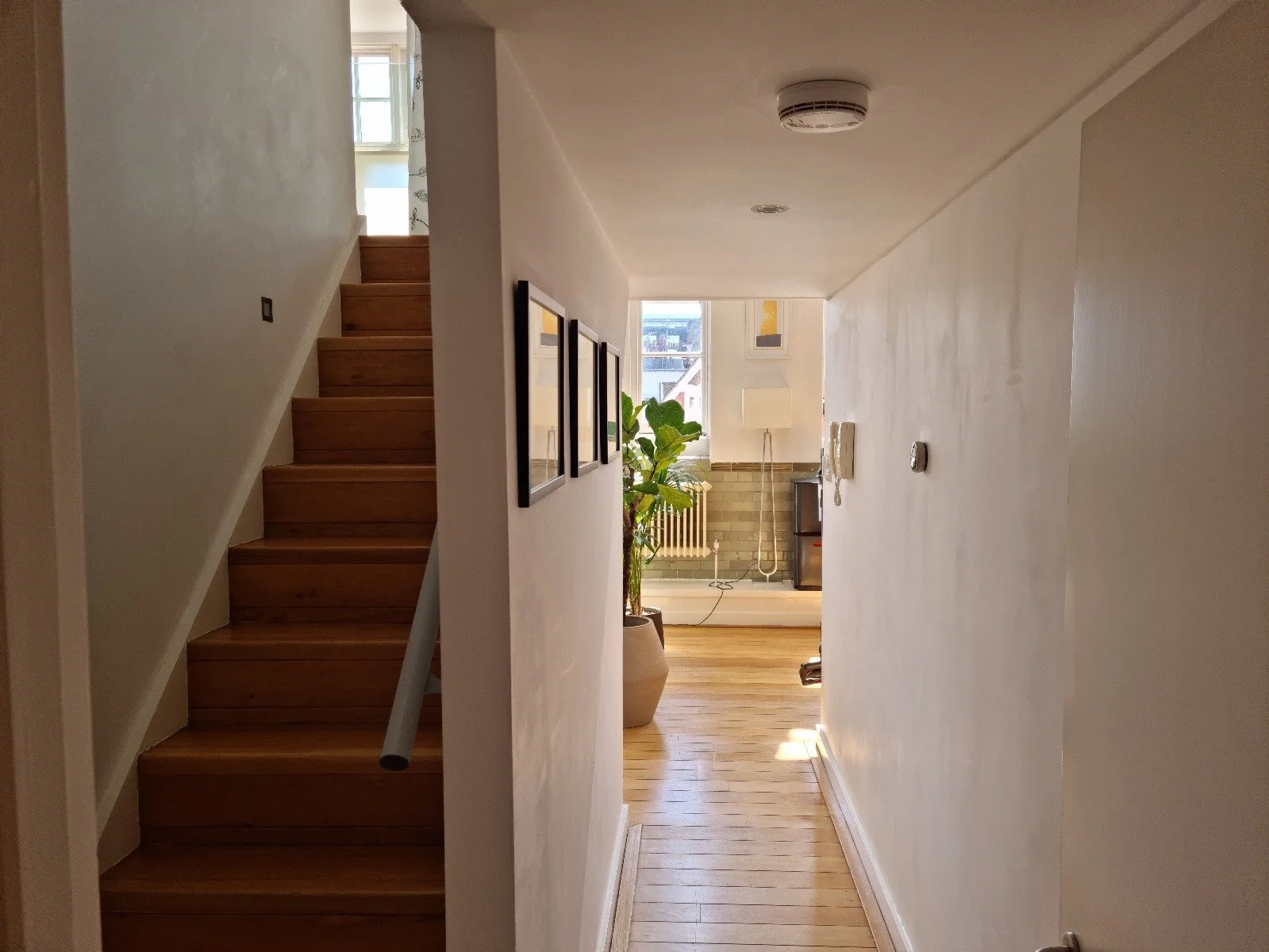 Before photo — staircase in a Grade II listed school conversion duplex London, plain timber treads, chrome handrail bracket, no step lighting, prior to Studio Akiva's renovation