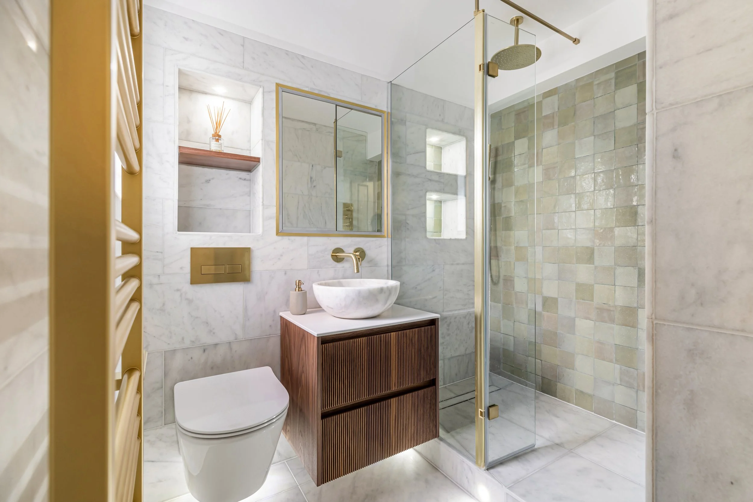 Olive-green zellige and honed Carrara marble from Mandarin Stone. Brushed brass by Drench, mirror by CP Hart.