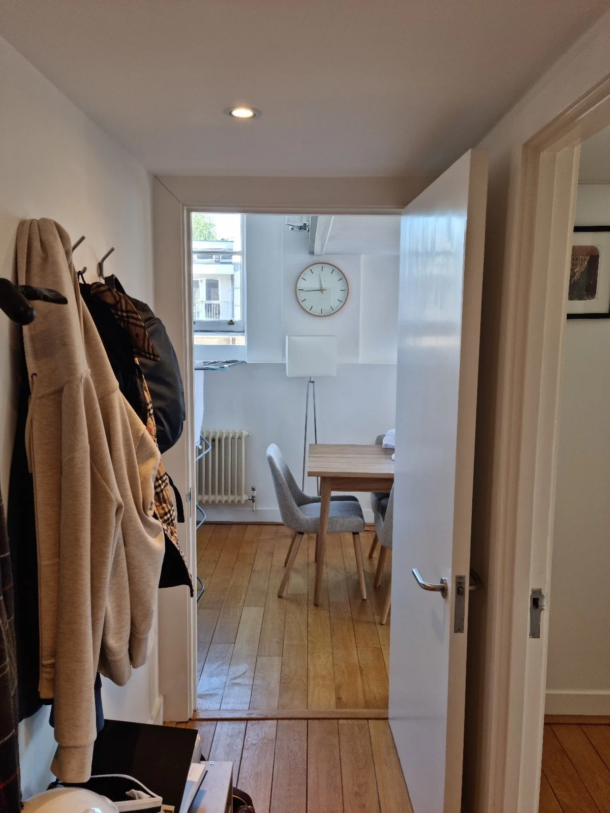 Before photo — narrow corridor in a Grade II listed duplex London showing hinged door blocking flow and worn original floorboards, prior to Studio Akiva's redesign