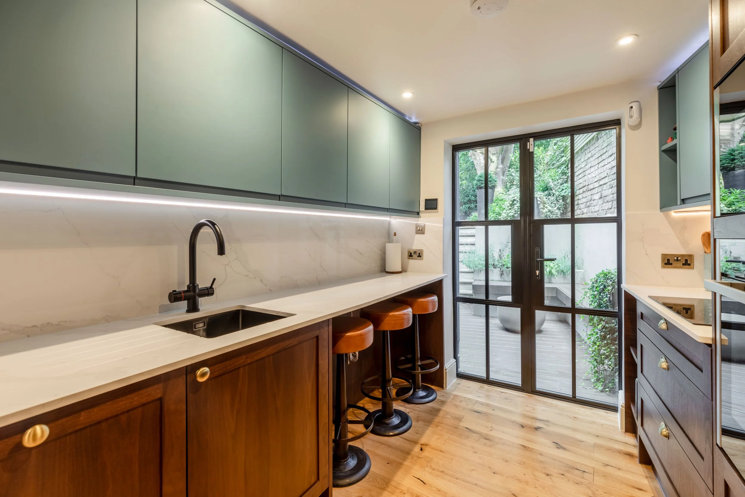 The relocated kitchen — Naked Kitchens doors on Howdens carcasses, antique brass hardware by Heritage Brass.