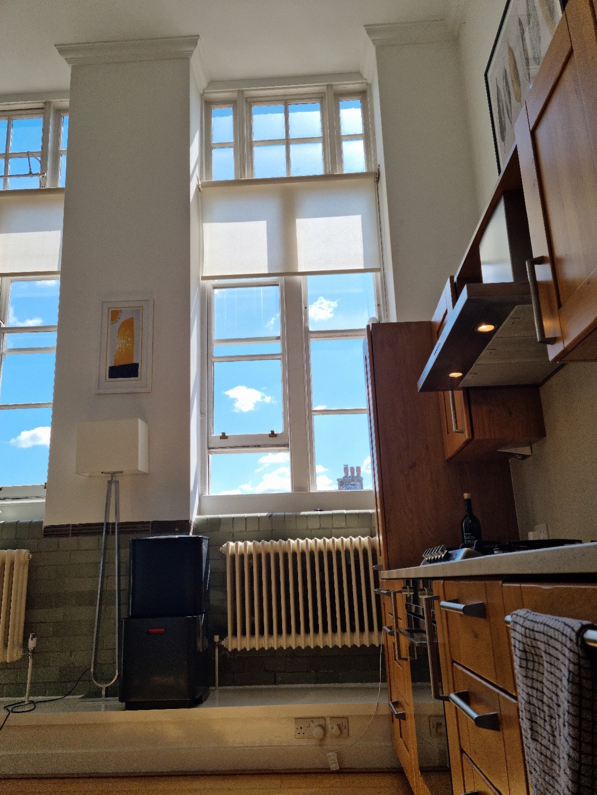 Before photo — honey pine shaker kitchen cabinets with chrome handles and granite-effect worktop in a Grade II listed school conversion duplex London, prior to Studio Akiva's renovation