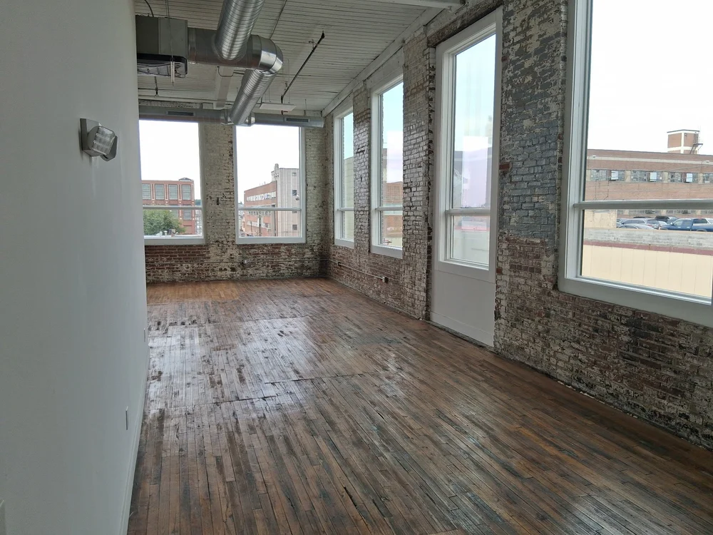 Private artist studio with brick walls, tall windows and hardwood floors at D Street Studios
