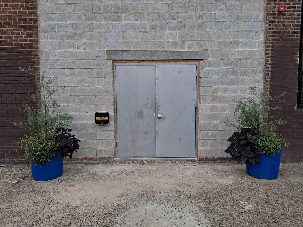 Wide exterior loading doors at D Street Studios, 500 E Tioga Street Philadelphia, with planters either side