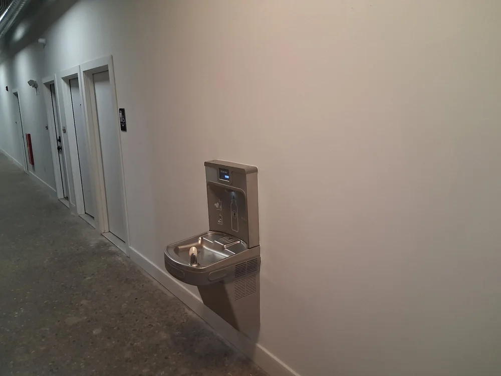 Corridor with drinking fountain outside the shared restrooms at D Street Studios