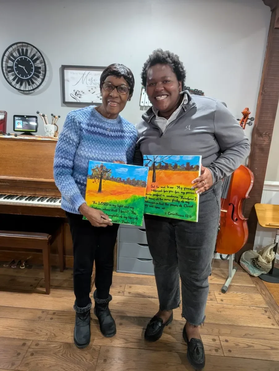 Two women celebrating their artwork together at a church gathering
