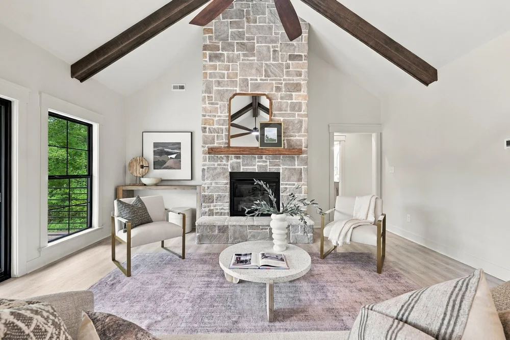 Great room with a stone fireplace and exposed wood beams