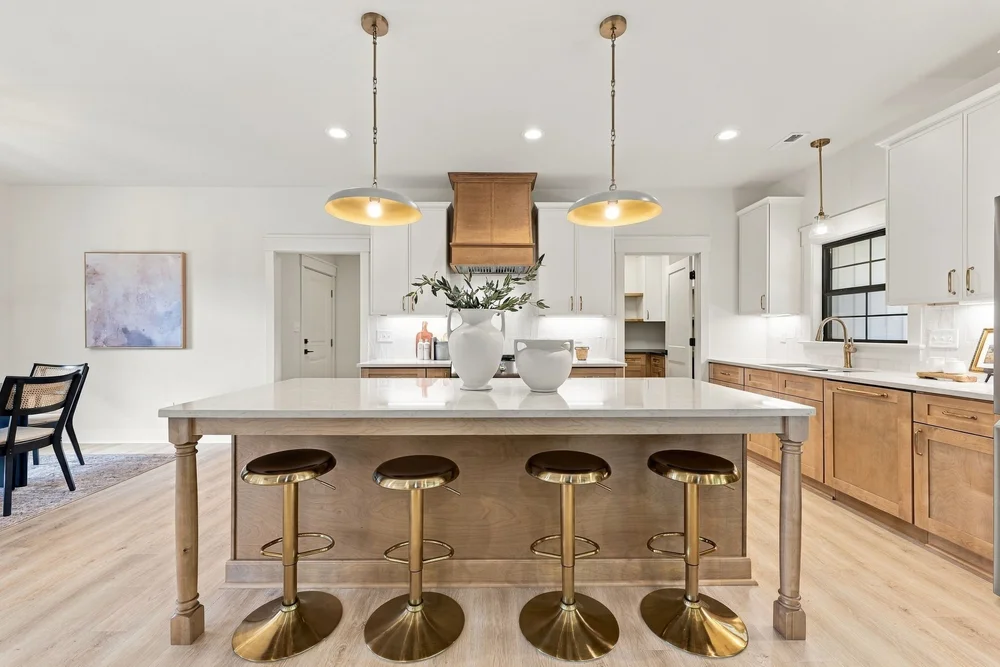 Kitchen with a large island, gold pendant lights and bar stools