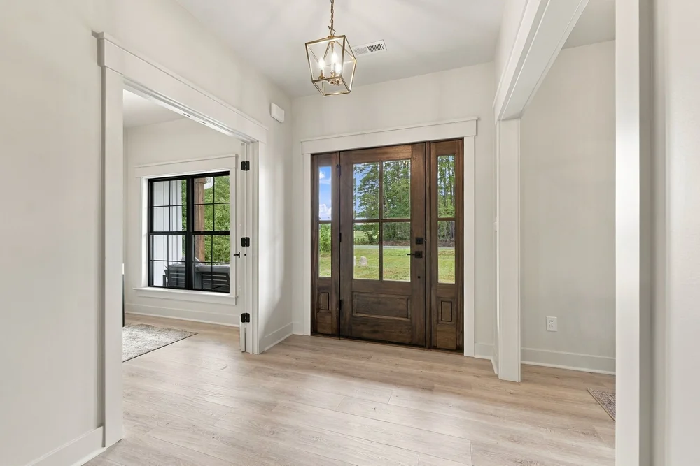 Bright foyer with a wood front door and pendant light