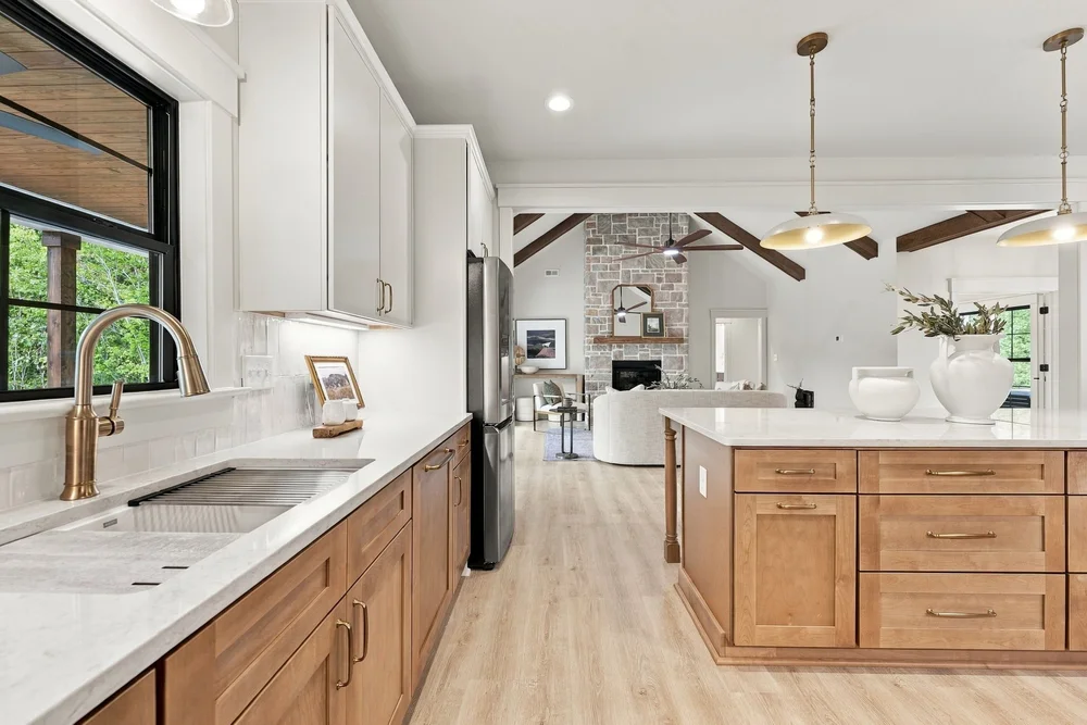 Kitchen with wood cabinets, a farmhouse sink and a view into the great room