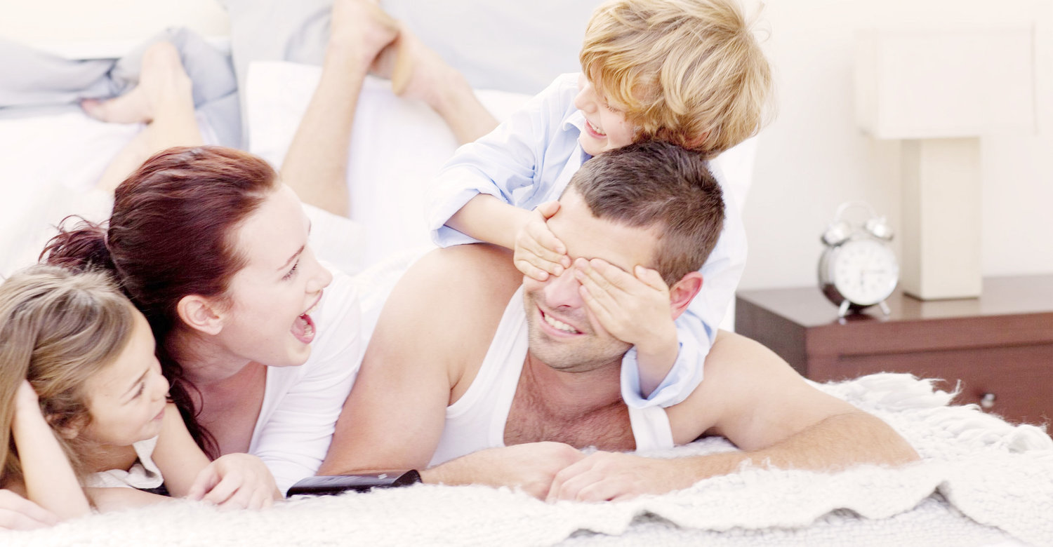 Счастливая семья в постели. Ребенок в кровати с родителями. Семья проснулась. Семья на кровати фотосессия.