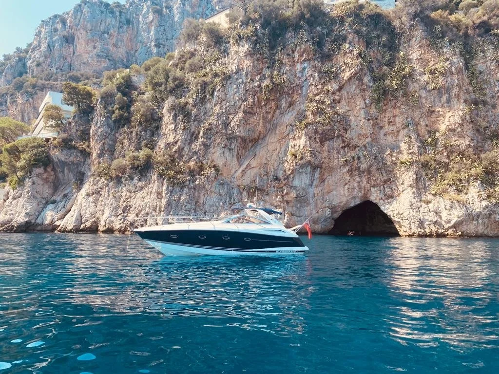 Beaulieu Boat Charters Sunseeker beside the rocky French Riviera coastline