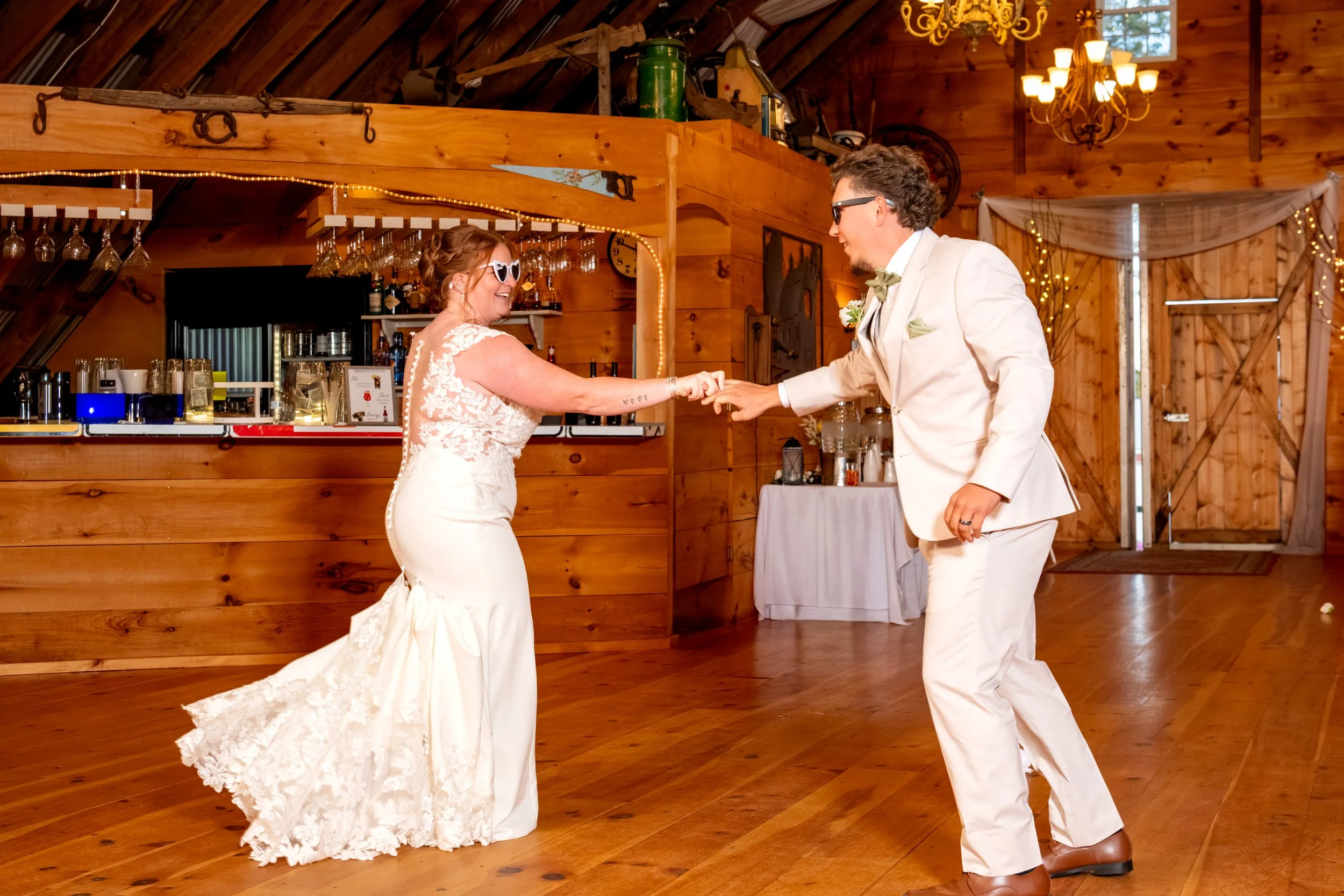 Andrew spinning Erika on the barn's wood floor during their entrance at the Maine Wedding Barn and Event Center in Minot Maine fall wedding photography VMG Productions