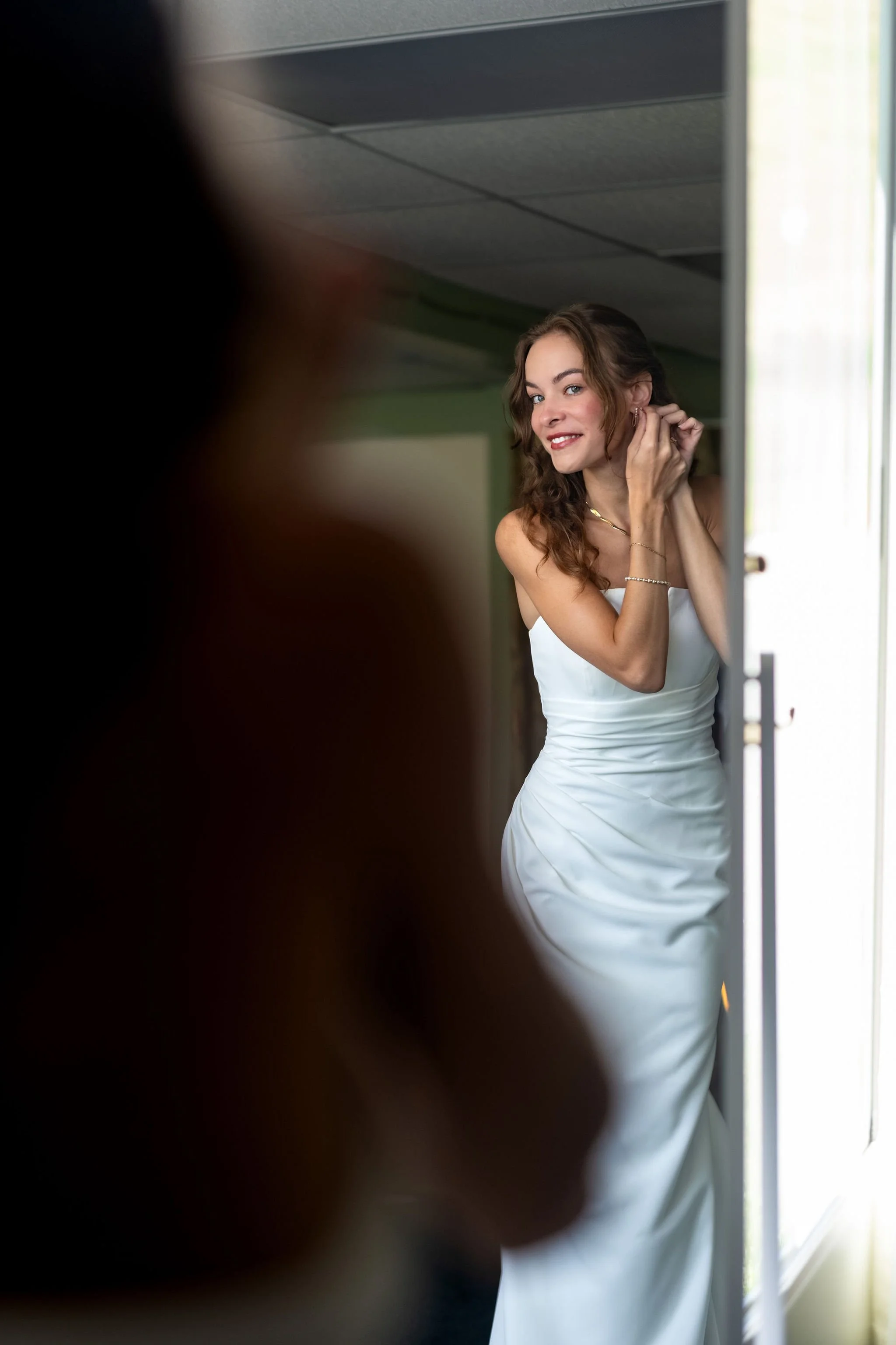 Cassidy Begin in her gown pausing in the doorway before walking to the ceremony at Maple Hill Farm Inn and Conference Center in Hallowell Maine summer wedding photography VMG Productions