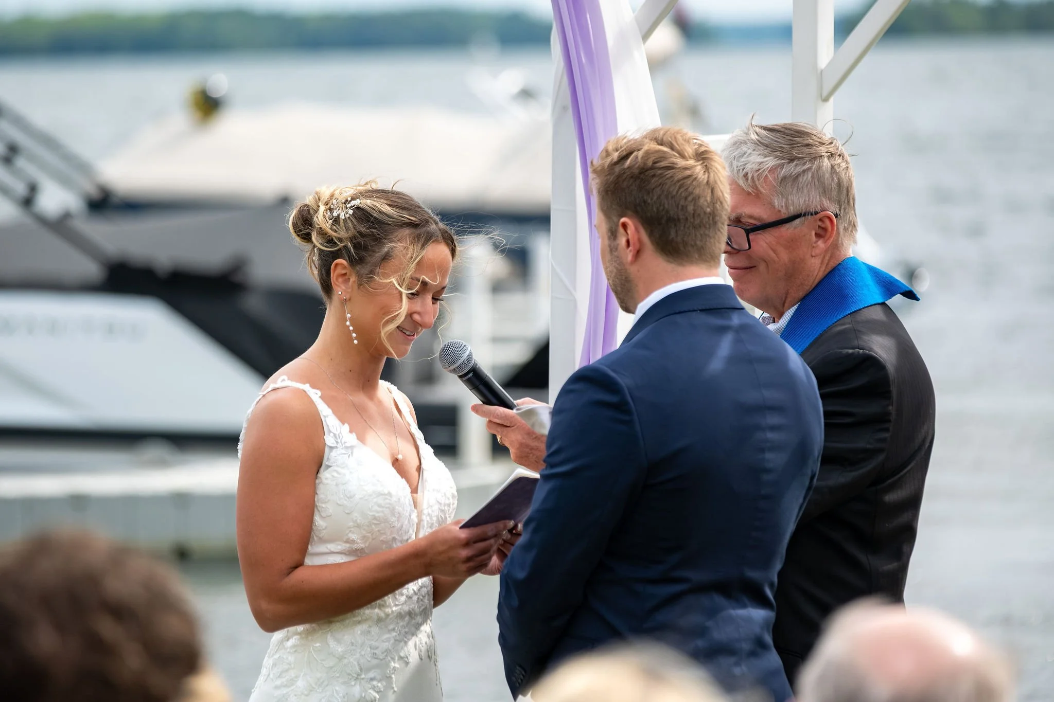 Beth and Cameron bride and groom holding hands during the ceremony at Augusta Country Club Manchester Maine spring wedding photography VMG Productions