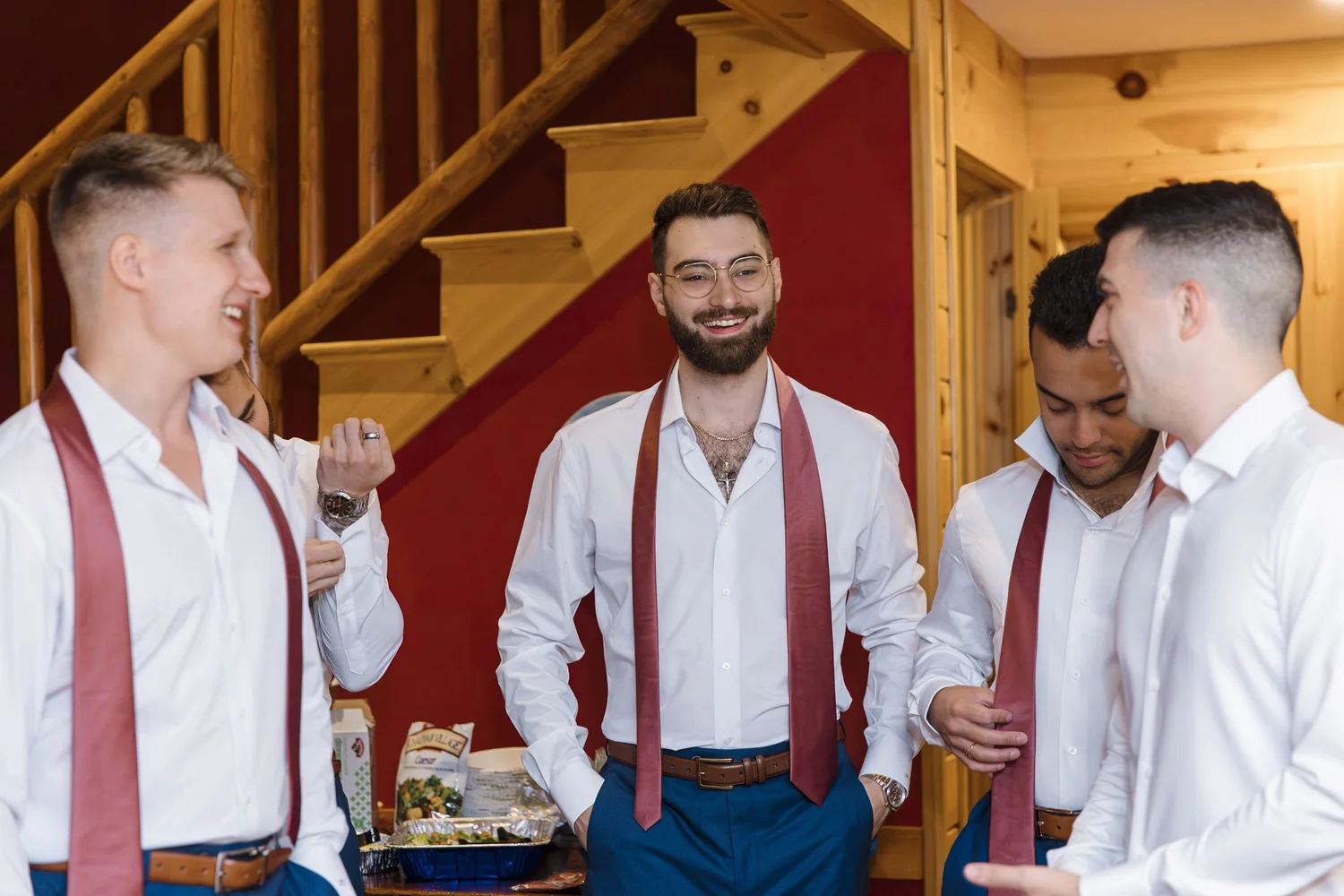 Groomsmen laughing together while getting ready at Hardy Farm Fryeburg Maine summer wedding