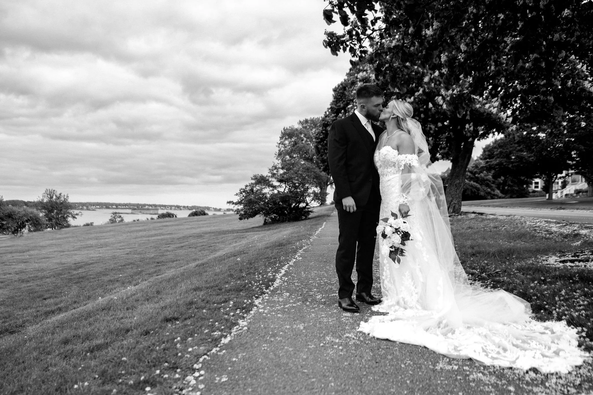 Jeremiah and Vienna couple shares a joyful laugh while standing close together at Eastern Promenade Portland Maine spring wedding photography VMG Productions