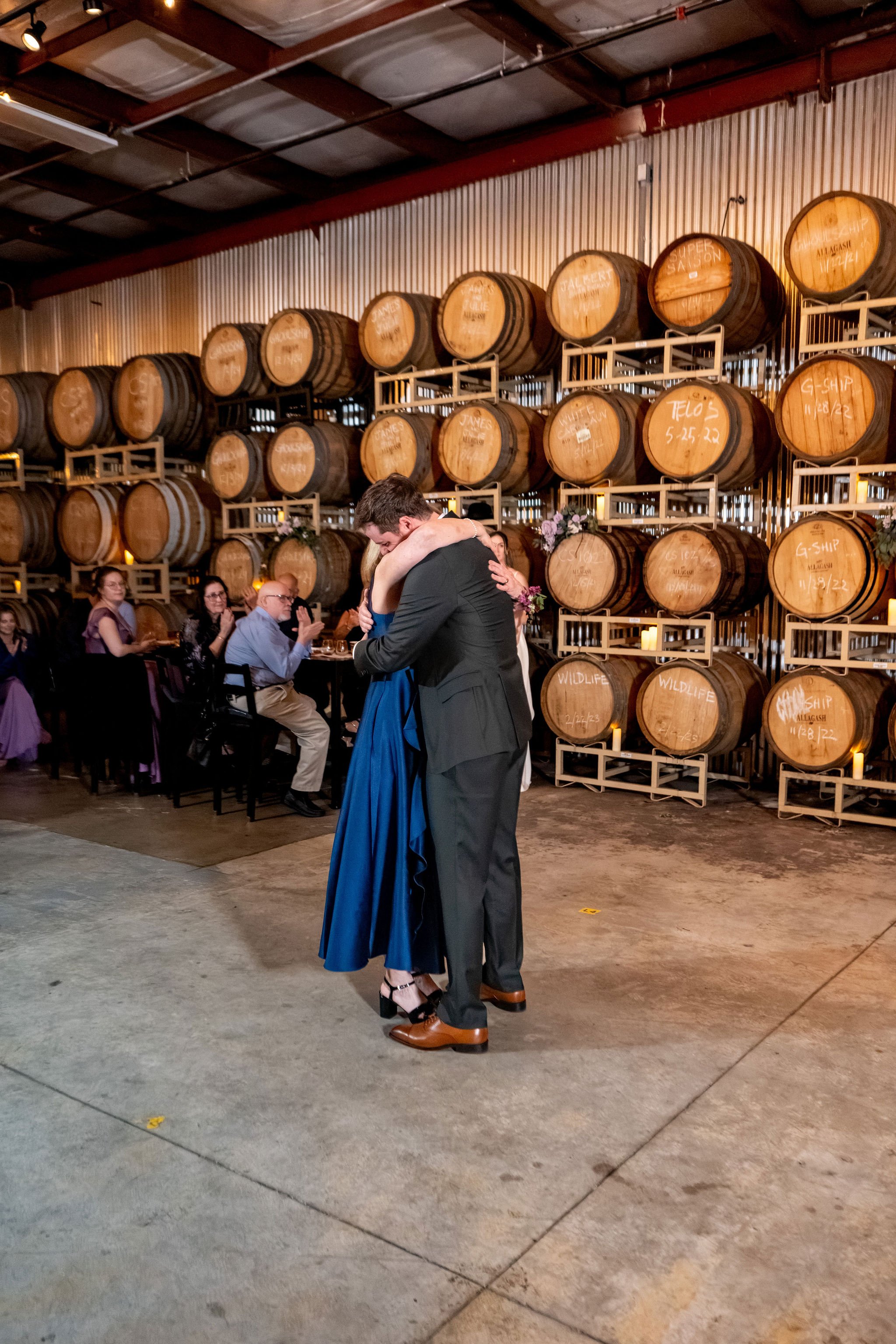 Jack wrapping his mom in a hug at the end of their mother son dance at The Cellars at Allagash Brewing Company in Portland Maine fall wedding photography VMG Productions