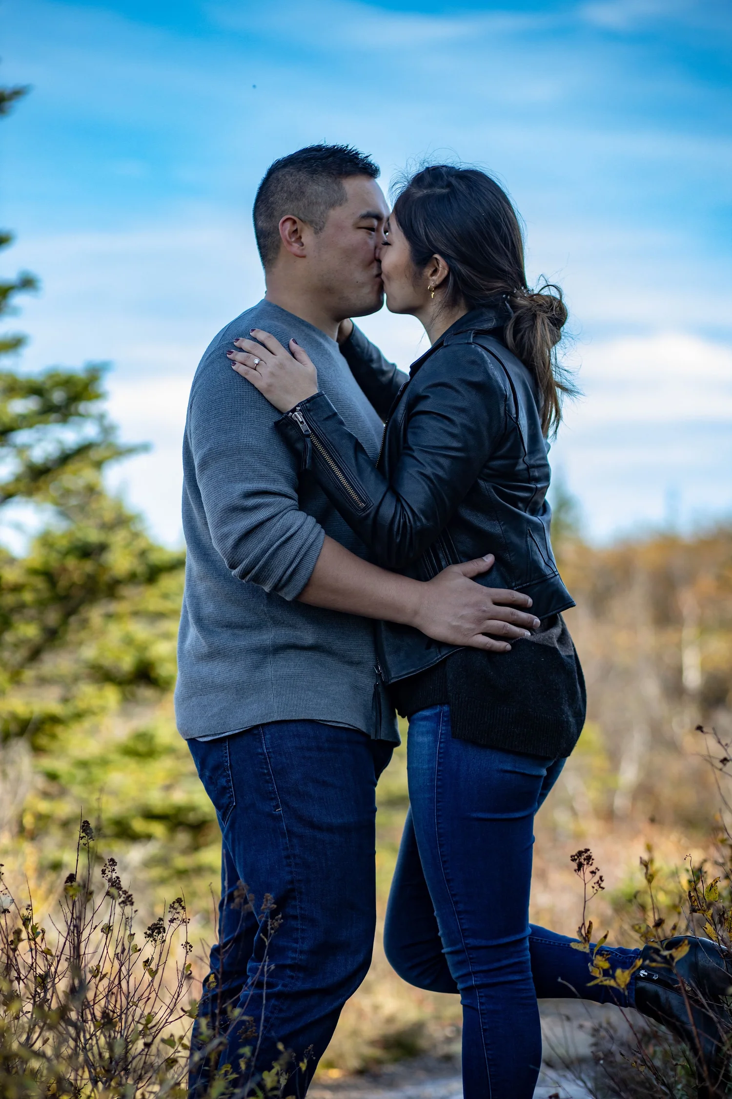 Agnes and Peter kissing on Cadillac Mountain fall foliage blue sky Acadia National Park engagement photography VMG Productions