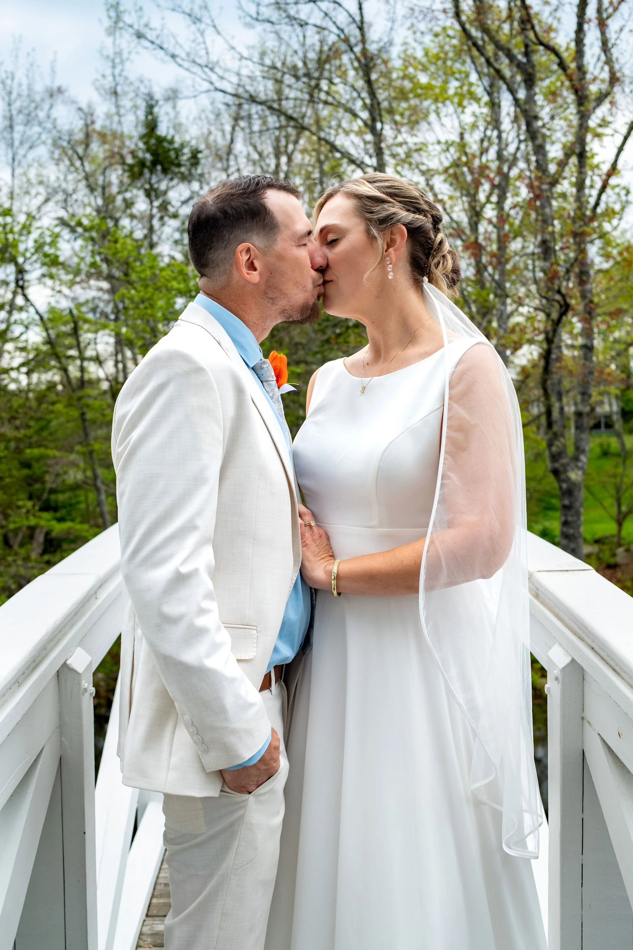 Alli and Adam Baudoin standing together on the white Somesville bridge in Somesville Maine spring wedding photography VMG Productions