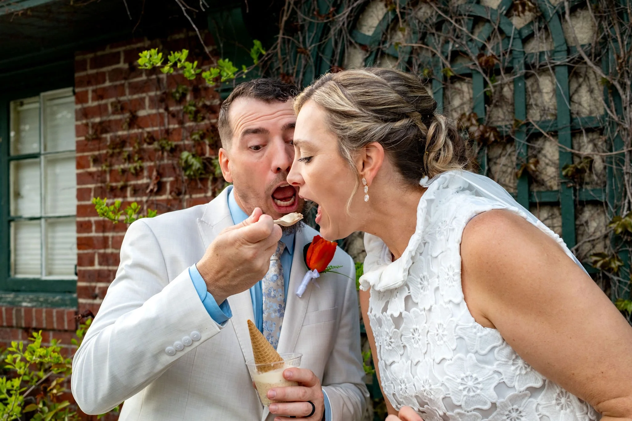 Adam Baudoin feeding Alli a spoonful of ice cream from Mount Desert Island Ice Cream in Bar Harbor Maine spring wedding photography VMG Productions