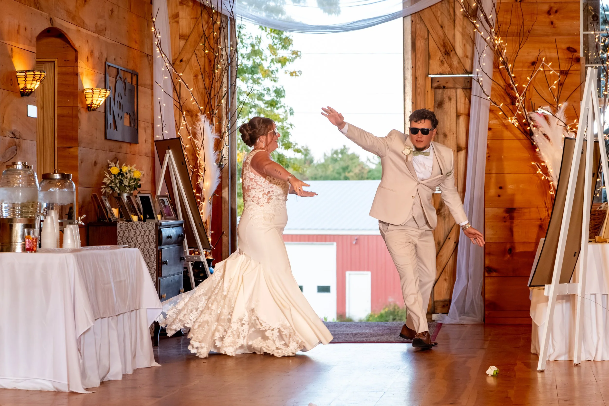 Erika and Andrew dancing through the barn doors for their grand entrance at the Maine Wedding Barn and Event Center in Minot Maine fall wedding photography VMG Productions