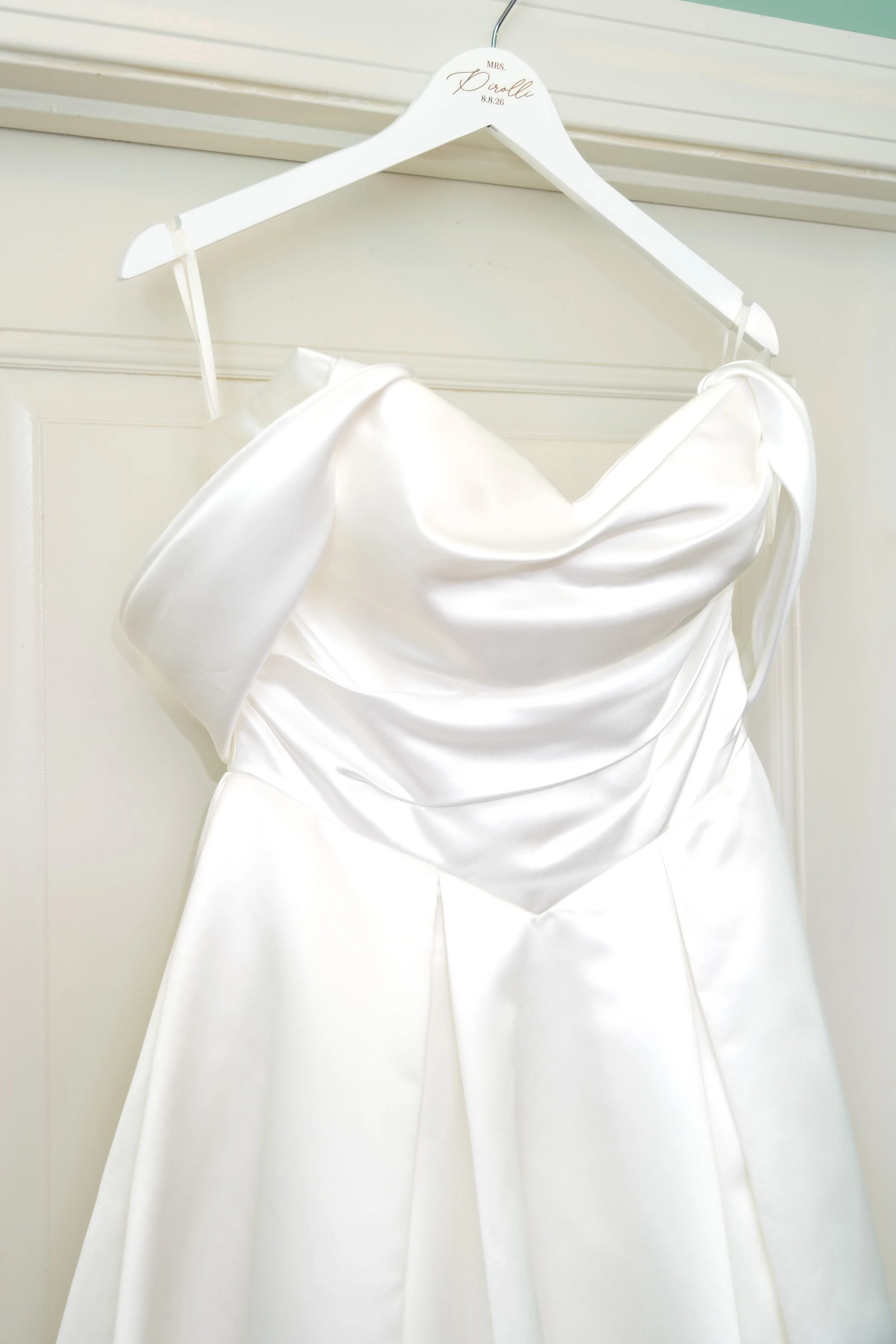 Caroline Pirolli's wedding gown on a custom Mrs. Pirolli 8.8.26 hanger in the bridal suite at Union Bluff Hotel in York Maine wedding photography VMG Productions