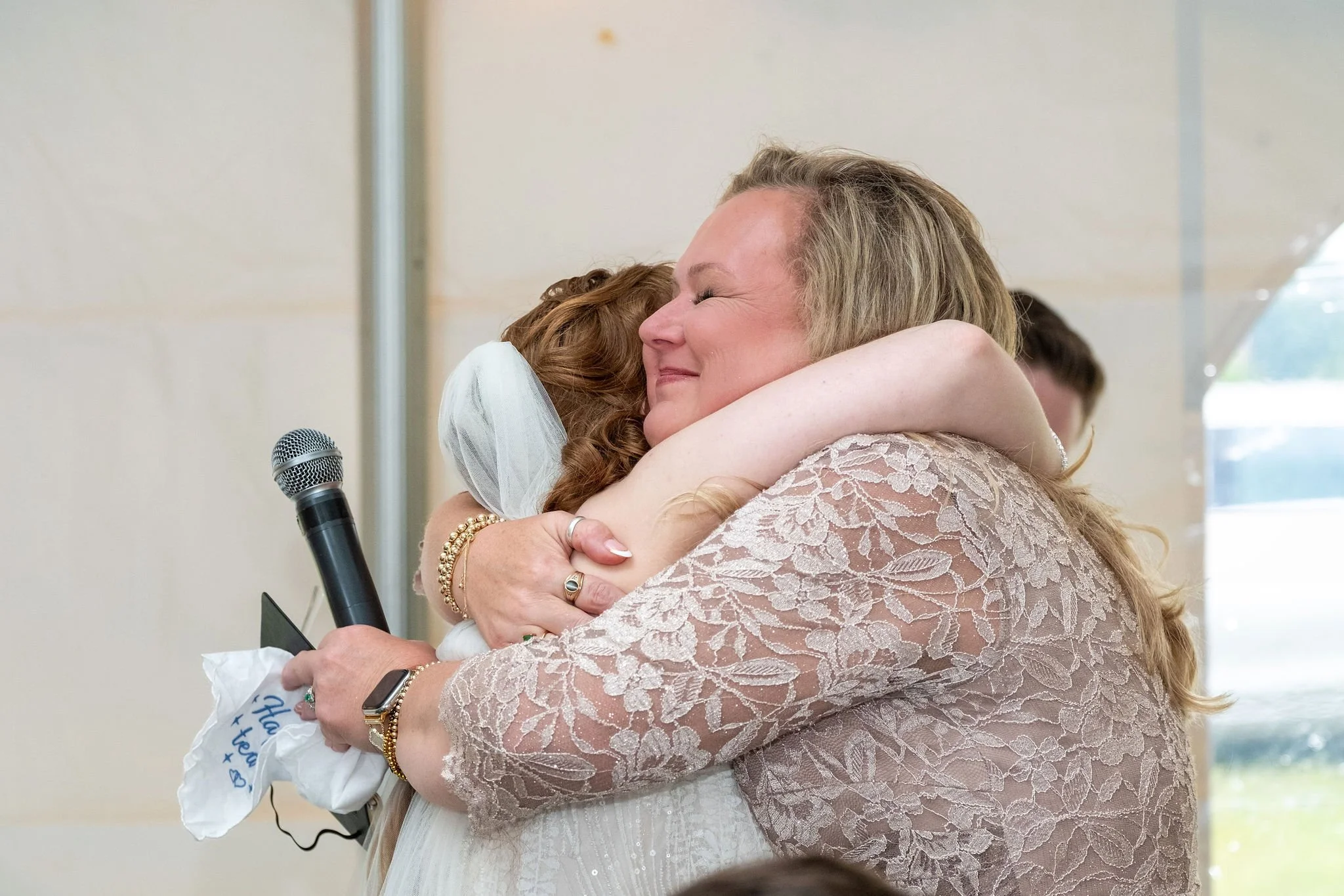 Kayla DeAngelis embracing her mother after her speech inside the reception tent at their Sanbornton New Hampshire wedding photography VMG Productions