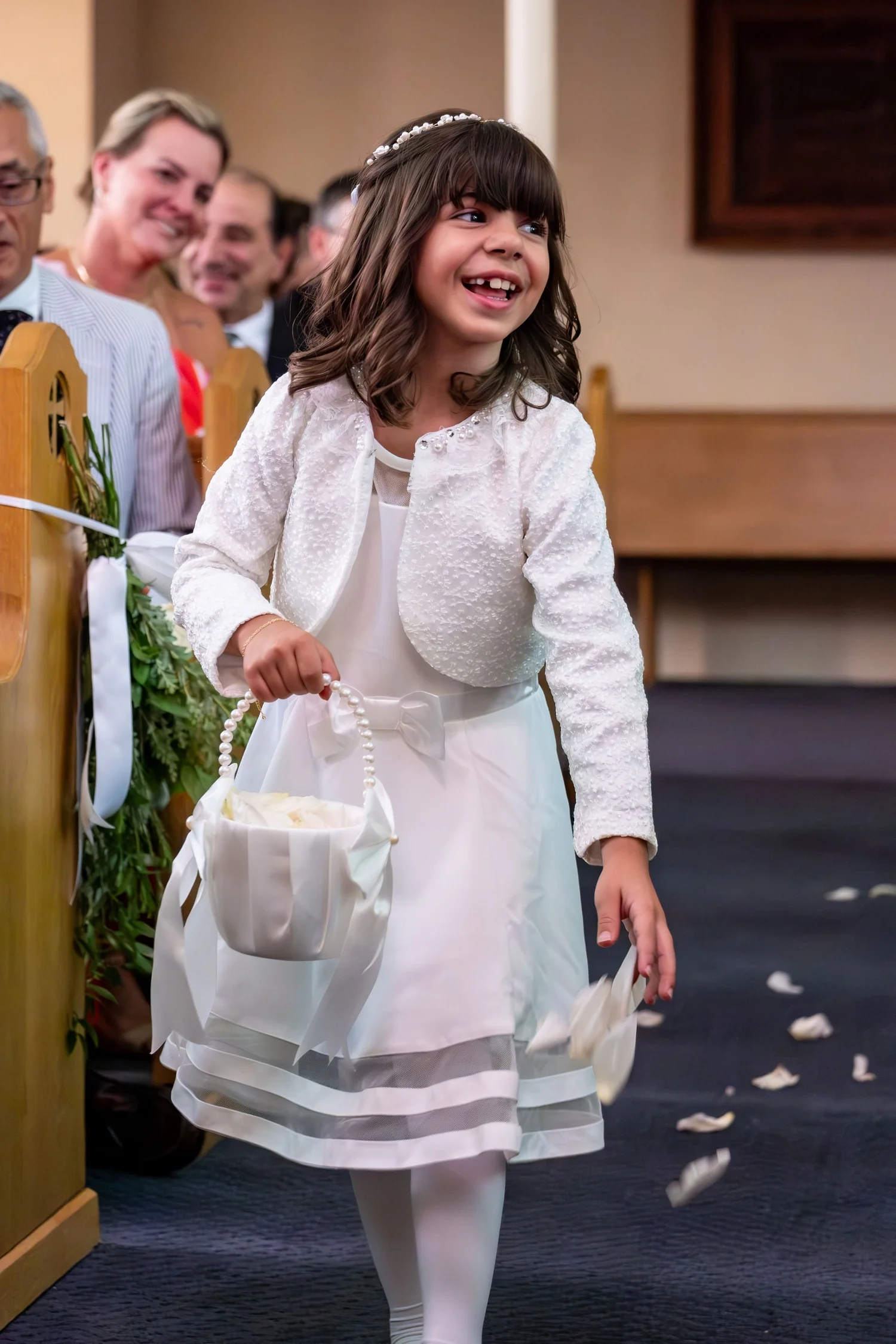 The flower girl scattering petals down the aisle at Holy Trinity Greek Orthodox Church Portland Maine summer wedding photography VMG Productions