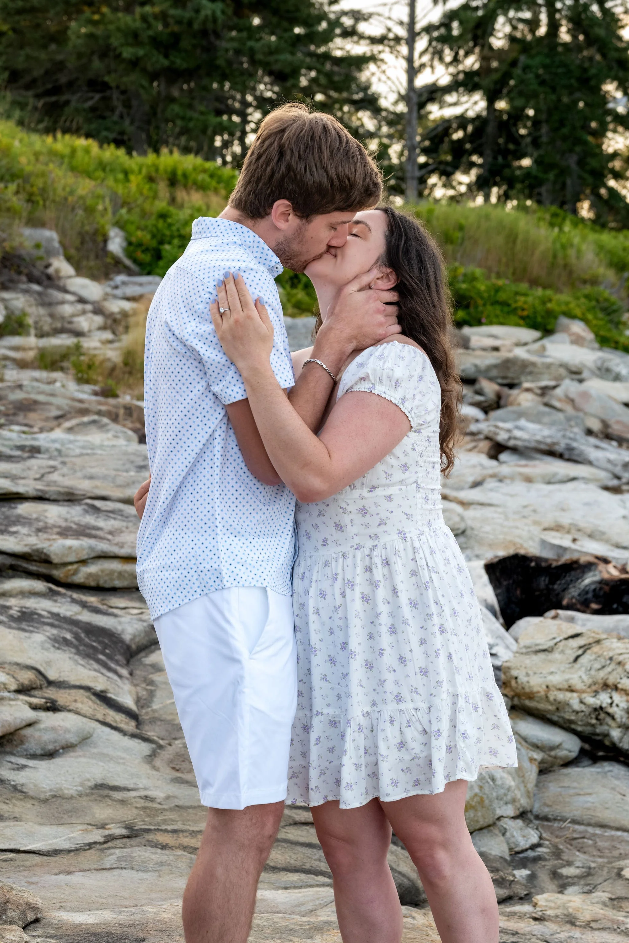 Kirstie and Lucas kissing on the granite ledges at Reid State Park in Georgetown Maine engagement photography VMG Productions