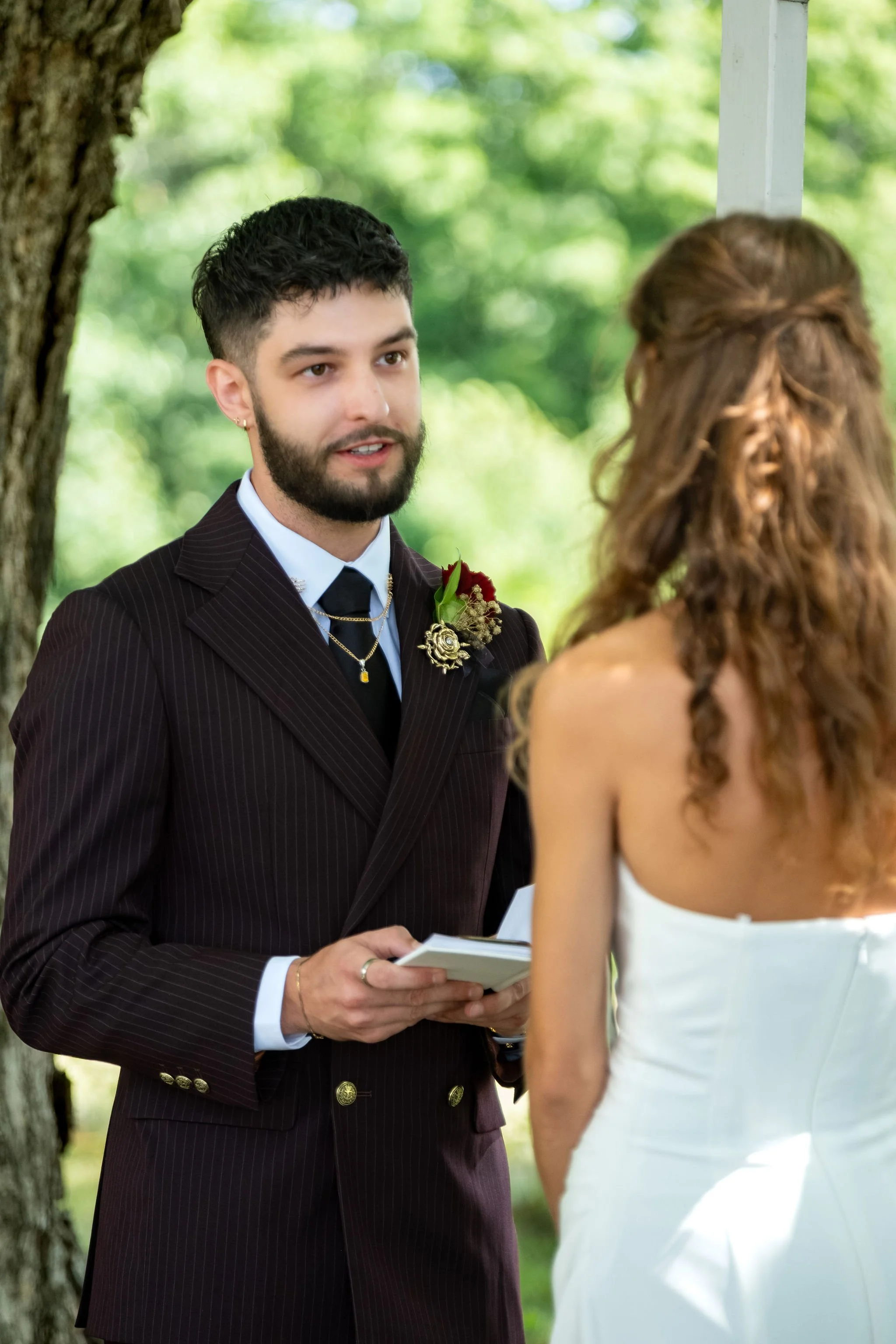 Chase Begin reading his vows to Cassidy at the arbor under the maples at Maple Hill Farm Inn and Conference Center in Hallowell Maine summer wedding photography VMG Productions