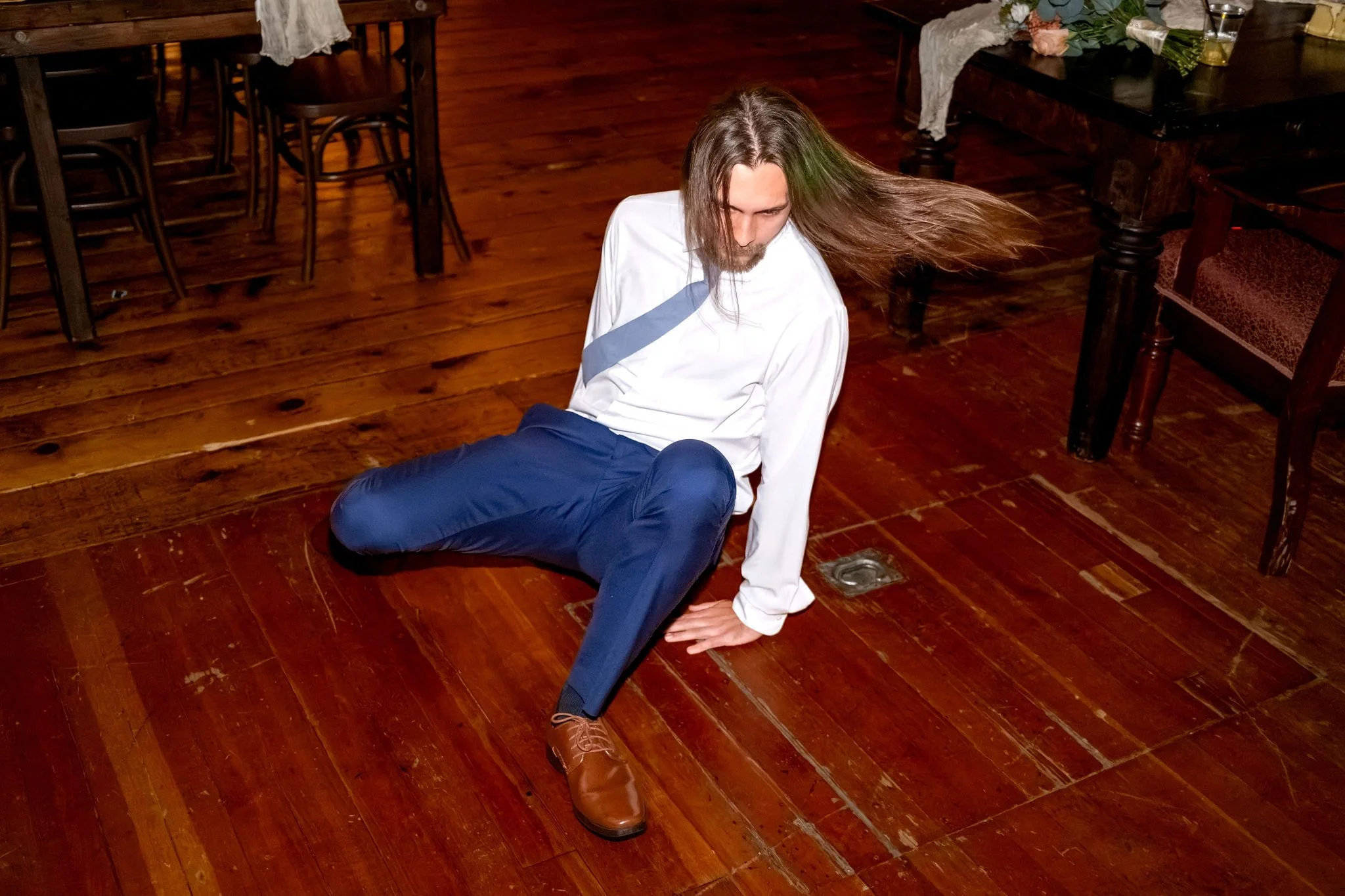 A groomsman dropping to the floor with his hair flying mid dance move at Boothbay Playhouse in Boothbay Maine fall wedding photography VMG Productions