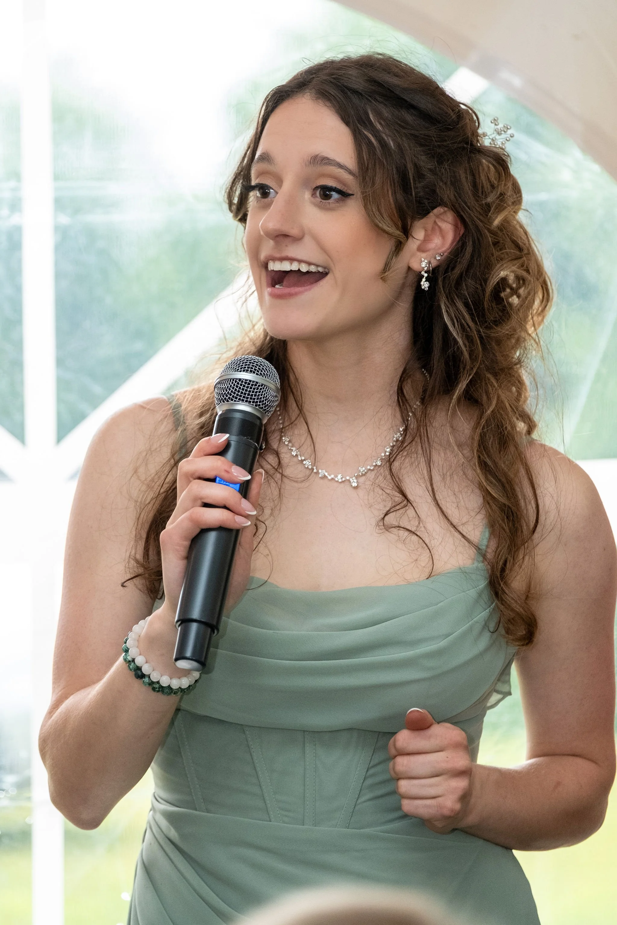 Kayla DeAngelis maid of honor delivering her speech inside the reception tent at the Sanbornton New Hampshire wedding photography VMG Productions
