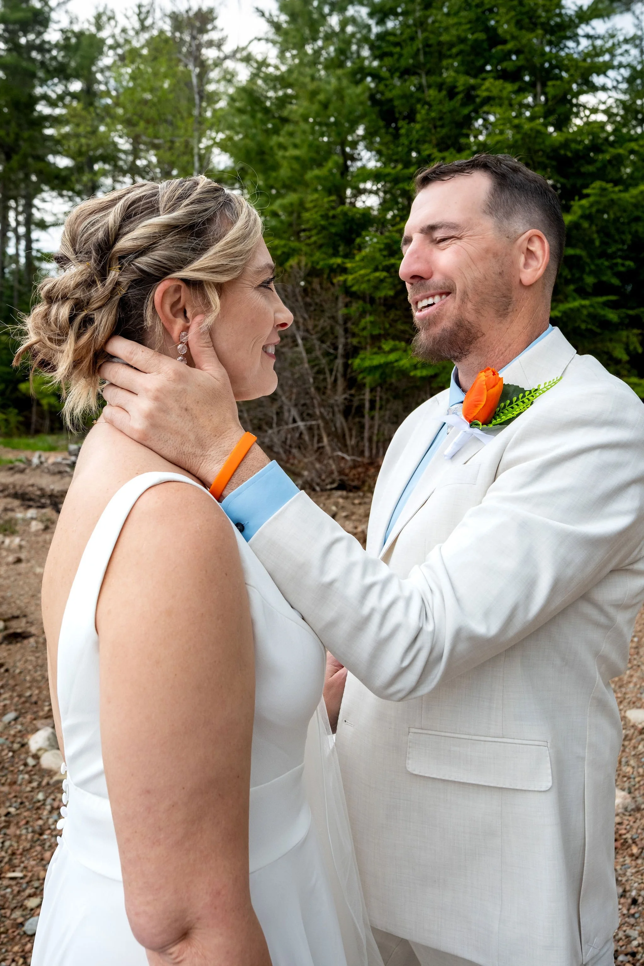 Adam Baudoin holding Alli close during their first look on the Somes Sound shoreline in Mount Desert Maine spring wedding photography VMG Productions