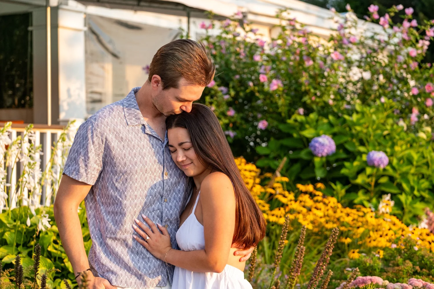 Couple embracing in a cottage flower garden, Peaks Island, Portland, Maine, by VMG Productions