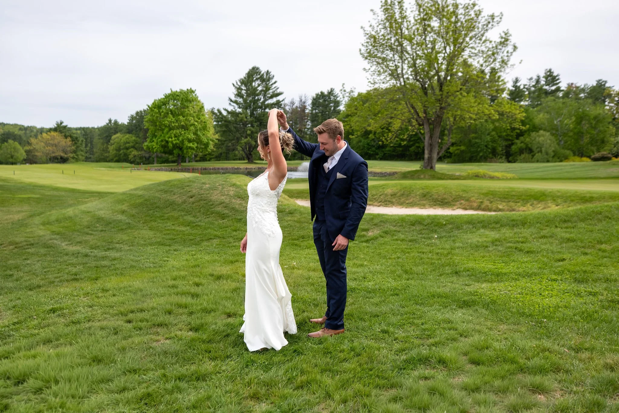 Beth and Cameron groom twirling the bride at their first look at Augusta Country Club Manchester Maine spring wedding photography VMG Productions
