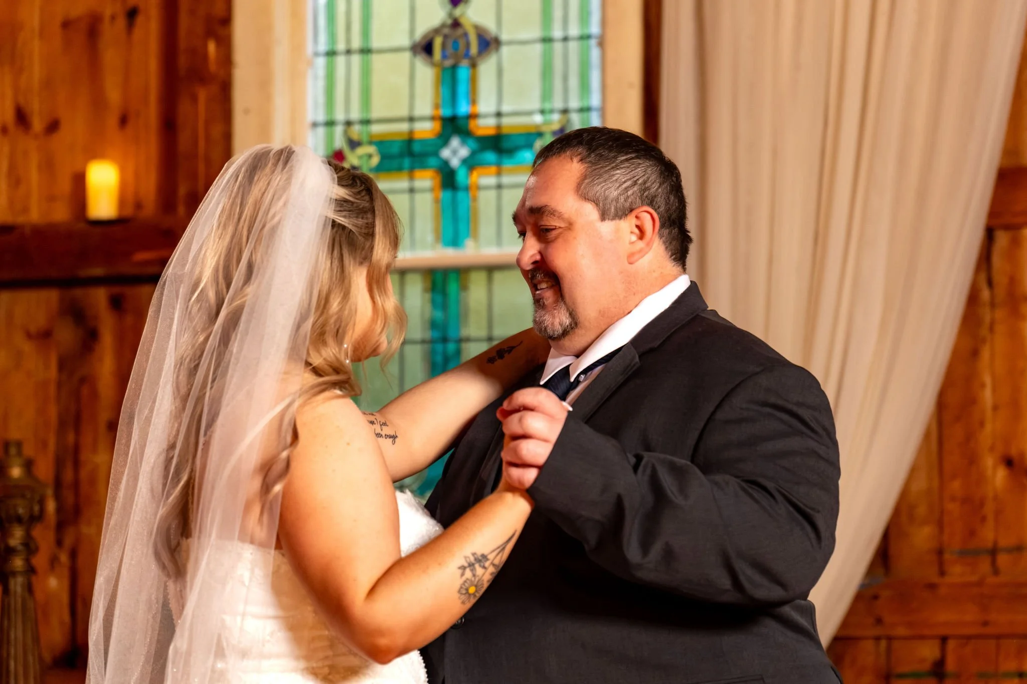 Ellie smiling as she dances with her dad in front of the stained glass window at Boothbay Playhouse in Boothbay Maine fall wedding photography VMG Productions