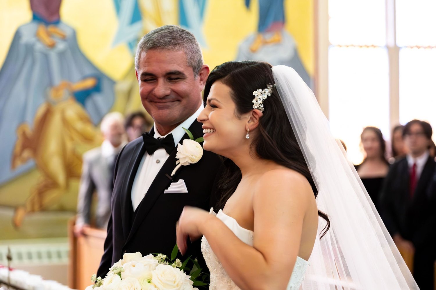 Nicole and Alexey smiling together beneath the murals at Holy Trinity Greek Orthodox Church Portland Maine summer wedding photography VMG Productions