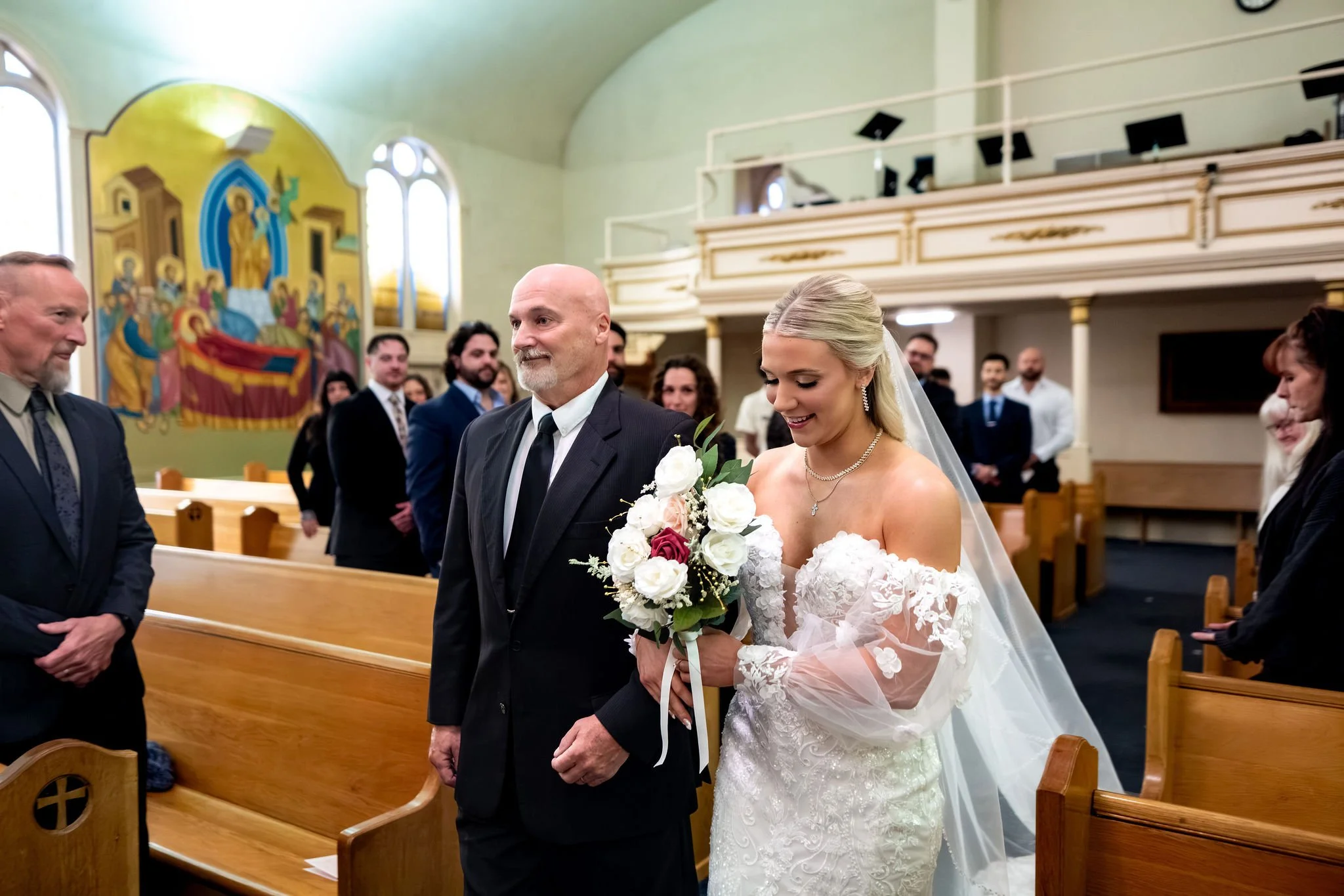 Jeremiah and Vienna alternative angle of bride entering ceremony with father at Holy Trinity Greek Orthodox Church Portland Maine spring wedding photography VMG Productions