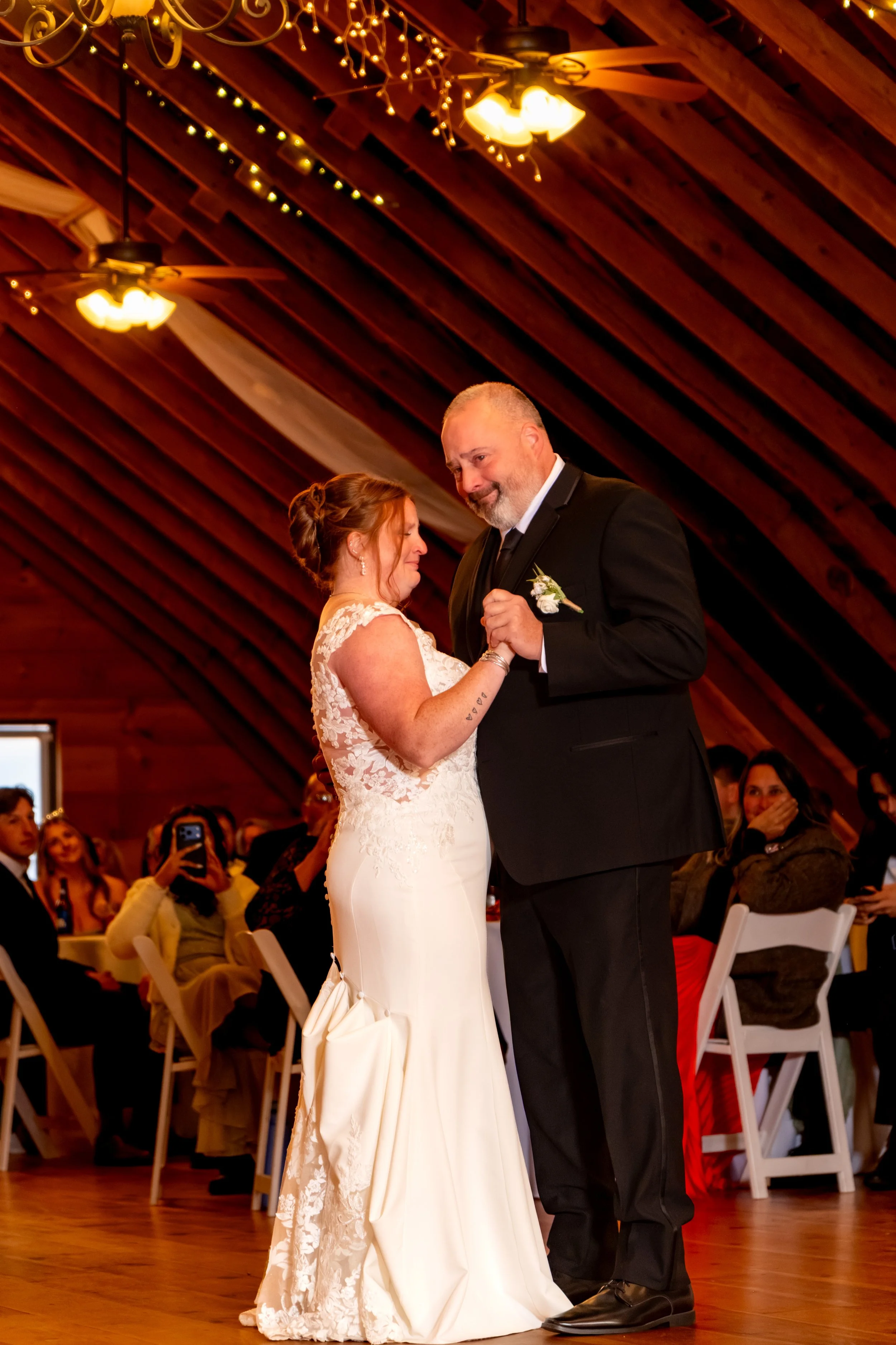 Erika dancing with her dad on the barn floor as he smiles down at her at the Maine Wedding Barn and Event Center in Minot Maine fall wedding photography VMG Productions