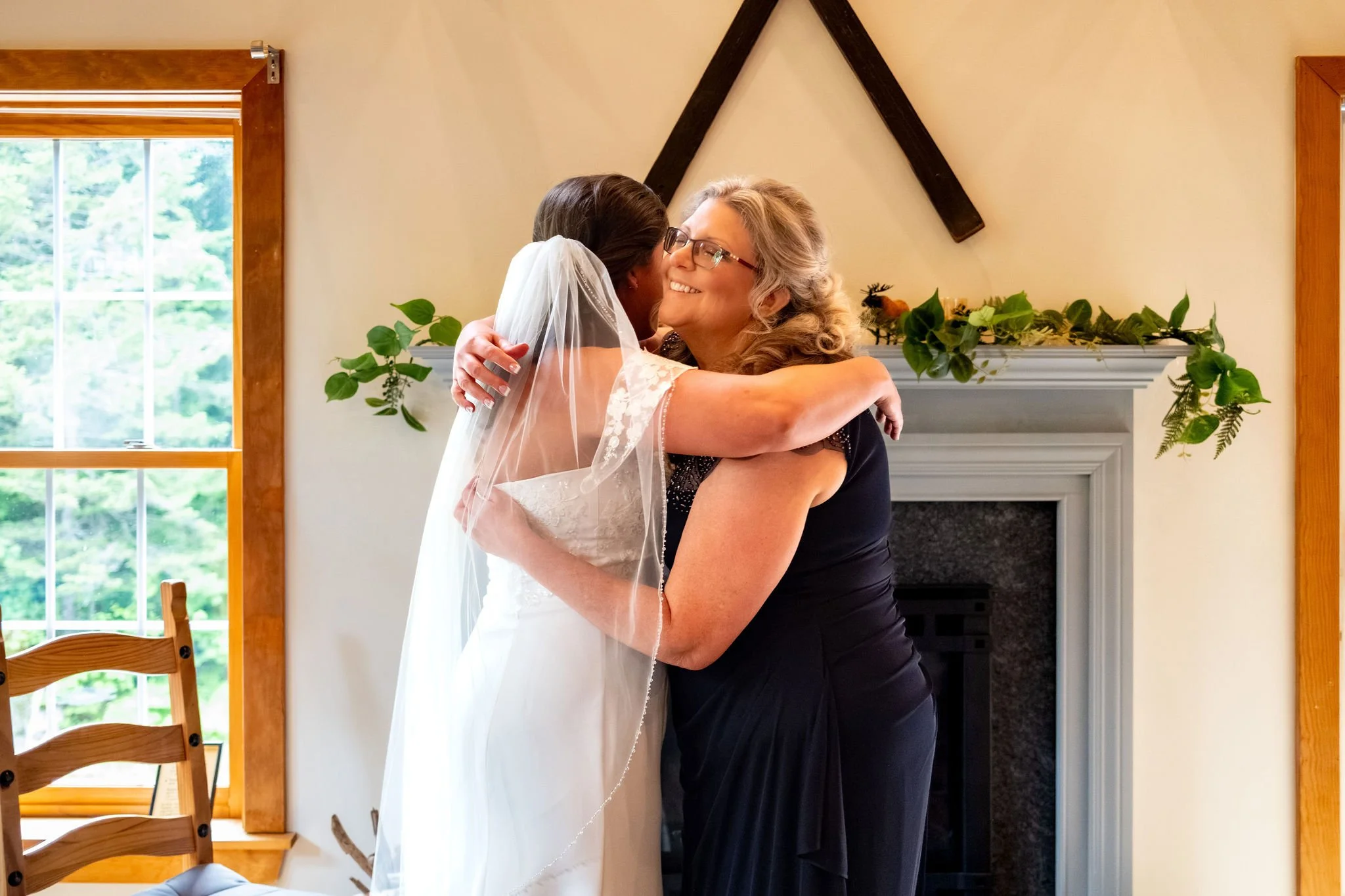 Alyssa and Colby the bride and her mom sharing a hug before leaving for the ceremony in Bethel Maine summer wedding photography VMG Productions