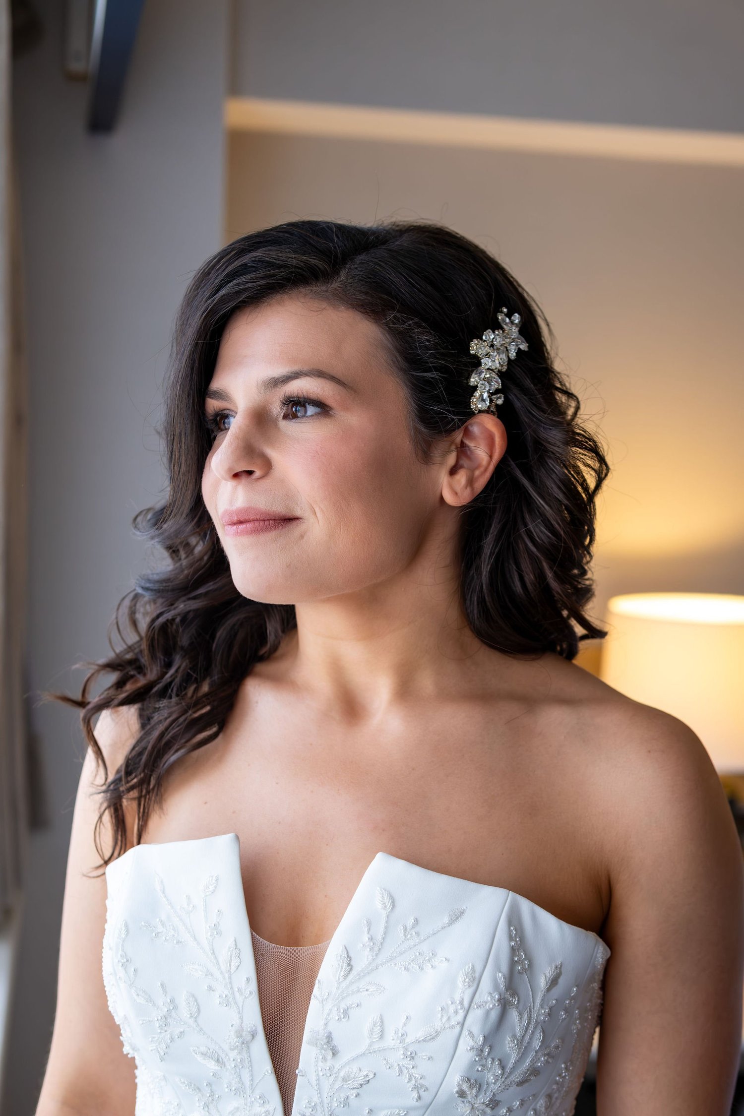 Nicole in her wedding dress looking toward the window light at Portland Sheraton at Sable Oaks South Portland Maine summer wedding photography VMG Productions