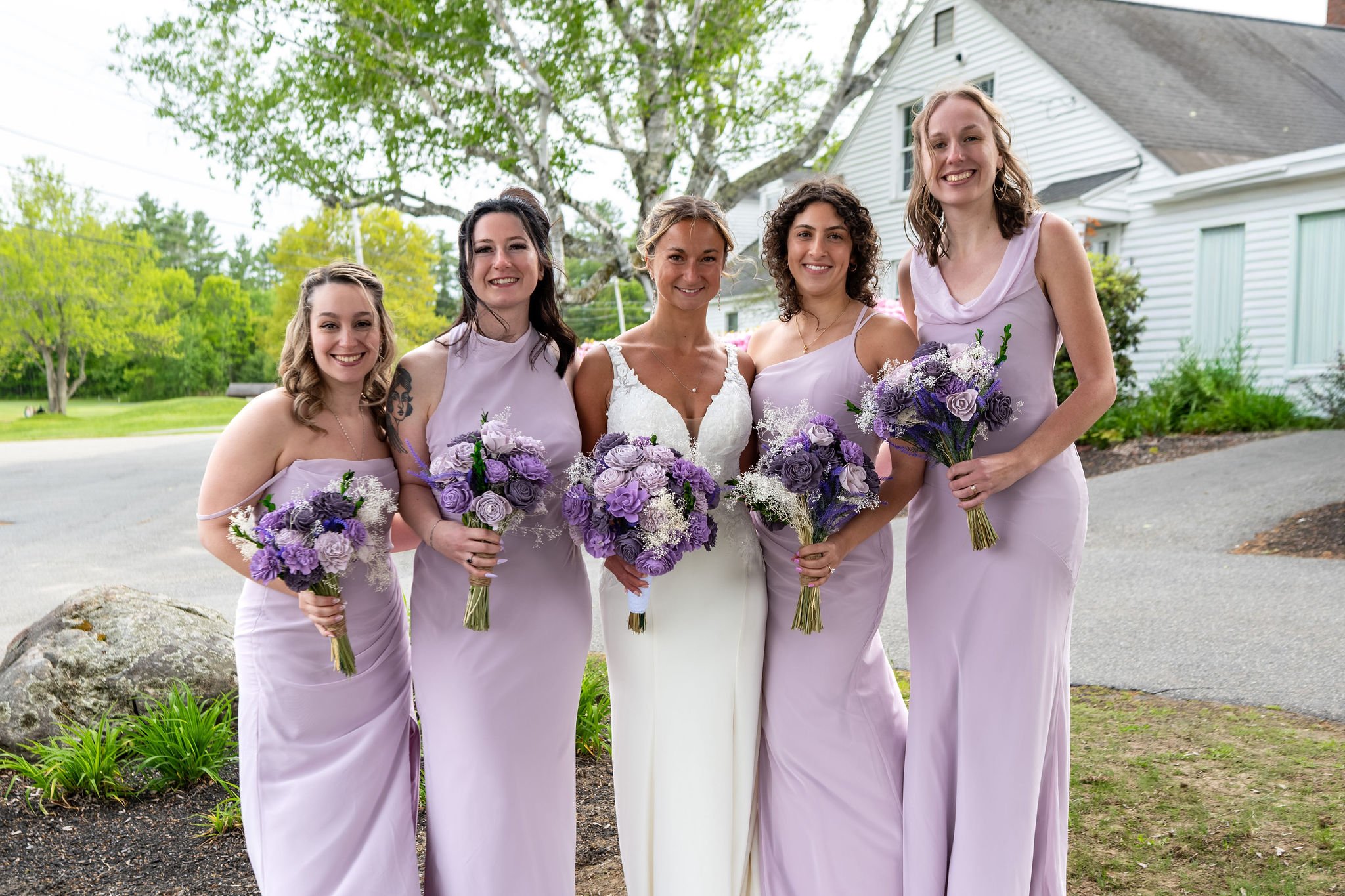 Beth and Cameron bride with her bridesmaids holding lavender bouquets at Augusta Country Club Manchester Maine spring wedding photography VMG Productions
